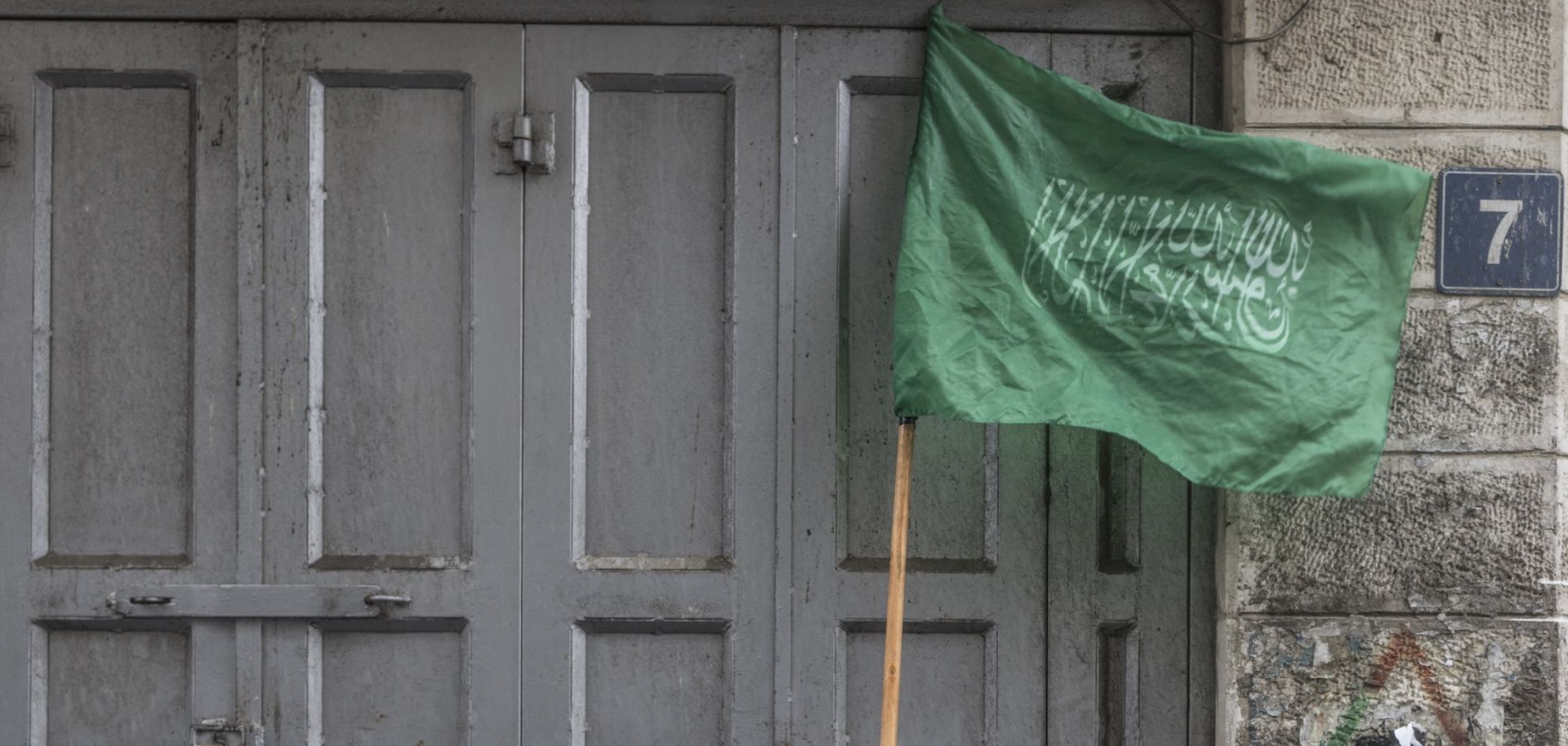 A child tapes a stick holding a Hamas flag during a demonstration in support of Palestinian resistance in the West Bank city of Ramallah, on Jan. 12, 2024. 