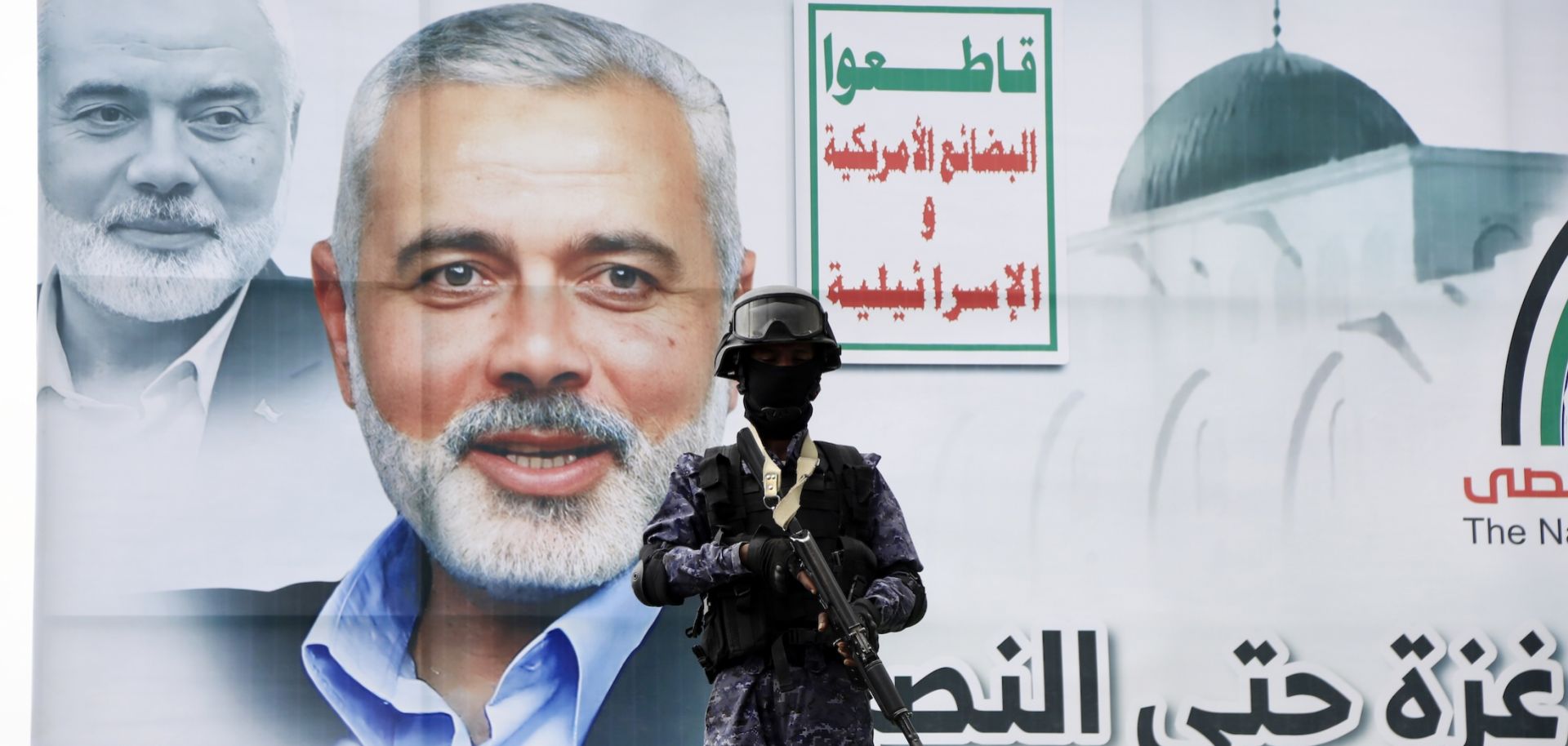 A security guard stands in front of a poster of Hamas' slain political leader, Ismail Haniyeh, on Aug. 2, 2024, in Sanaa, Yemen.