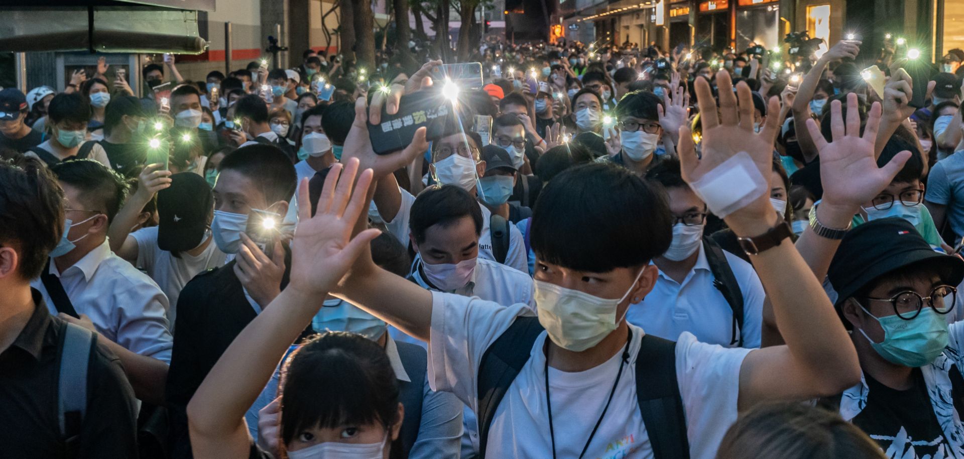 Pro-democracy protesters shine the flashlights on their cellphones as they take part in a rally in Hong Kong on June 9, 2020. 