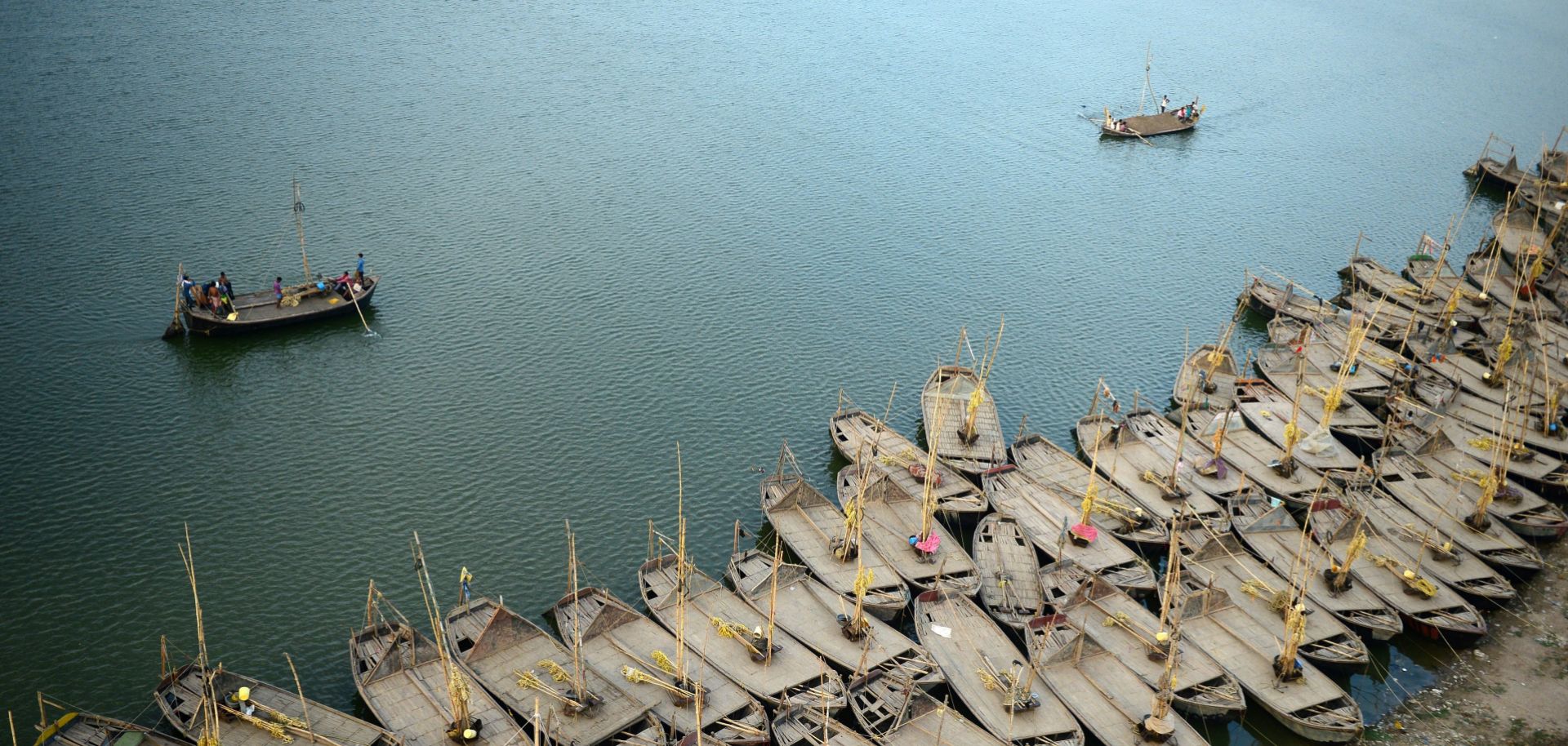 Indian workers use boats to remove sand from the River Yamuna in Allahabad on March 16, 2018. 