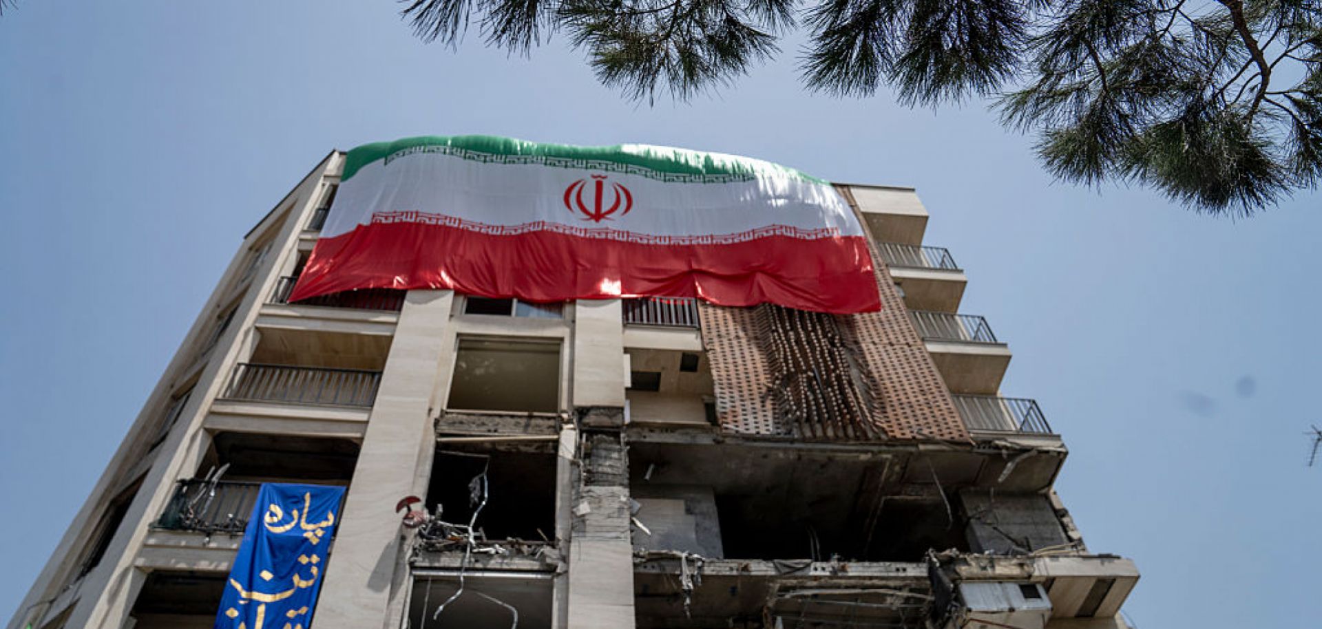 An Iranian flag is draped from a building damaged during a recent attack by Israel is seen in the Gisha neighborhood of Tehran, Iran, on June 25, 2025. 