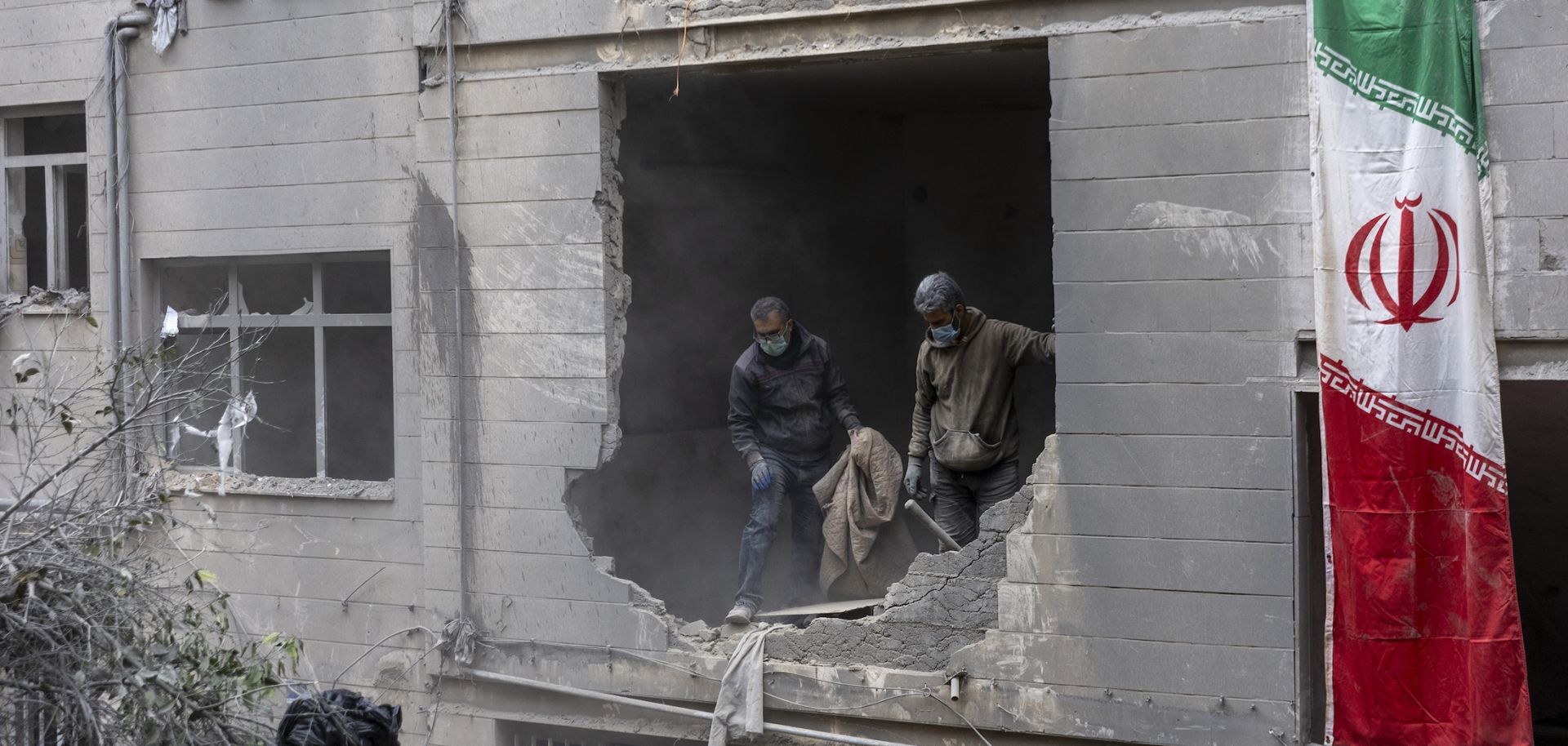 People on March 15 in Tehran, Iran, clean up rubble from a missile attack.