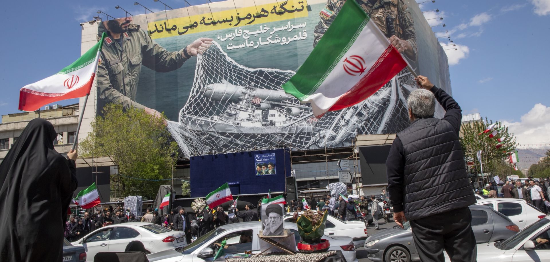 Iranians hold national flags as they gather in Tehran's Revolution Square after the United States and Iran agreed to a two-week ceasefire, on April 8, 2026 in Tehran, Iran.