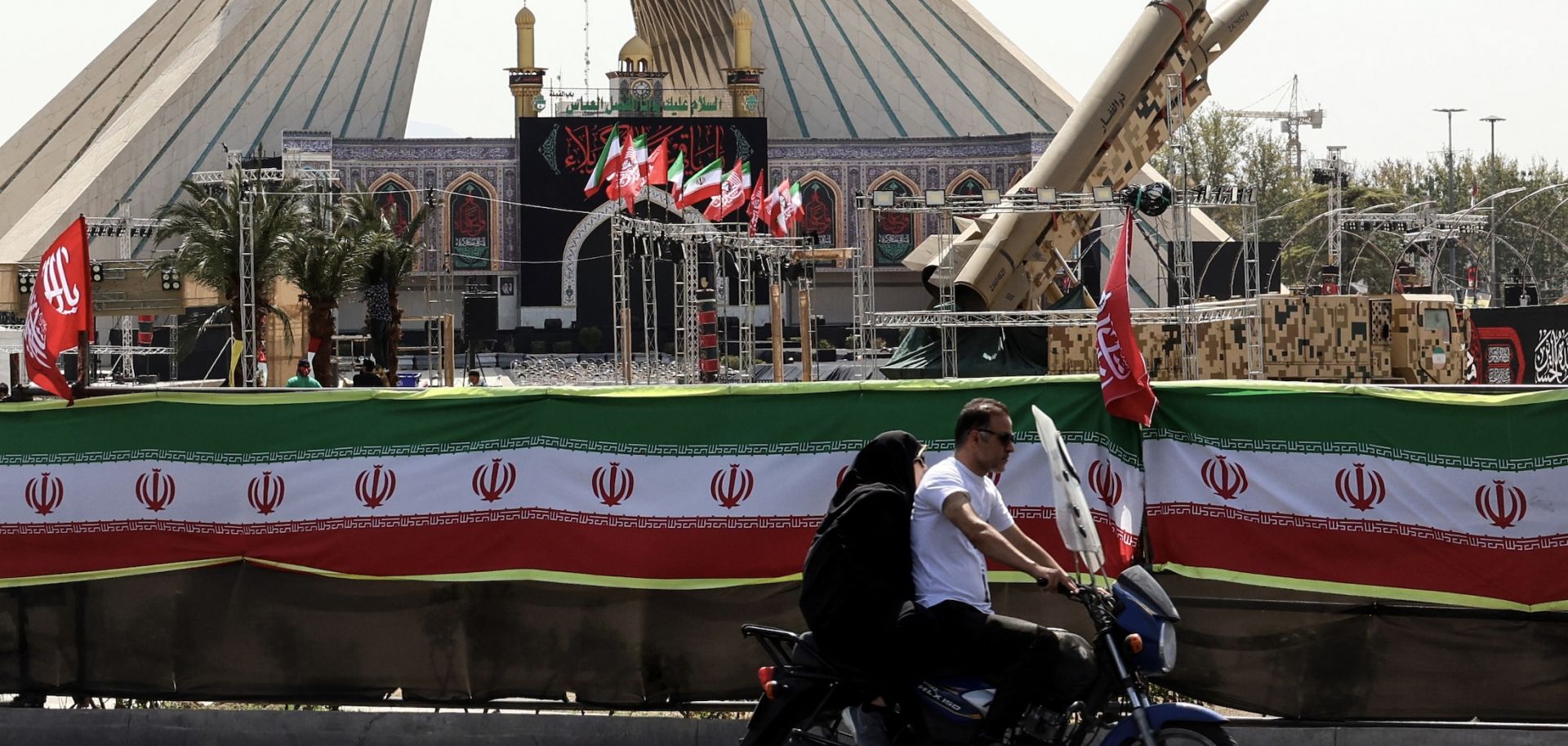 A couple rides past Iranian-made Zolfaghar missiles displayed at Azadi Square in Tehran on July 24.
