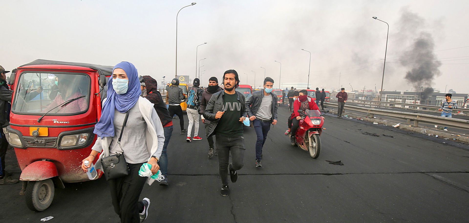 Iraqis run for cover during an anti-government demonstration in Baghdad on Jan. 23, 2020. Protests have rocked Iraq since October but recently had abated amid spiraling tensions between the country's key allies, the United States and Iran.