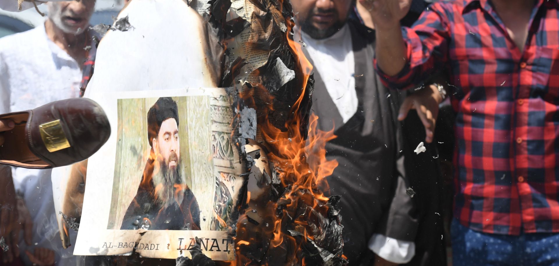 Protesters burn a picture of Islamic State leader Abu Bakr al-Baghdadi on June 9, 2017, in New Delhi.