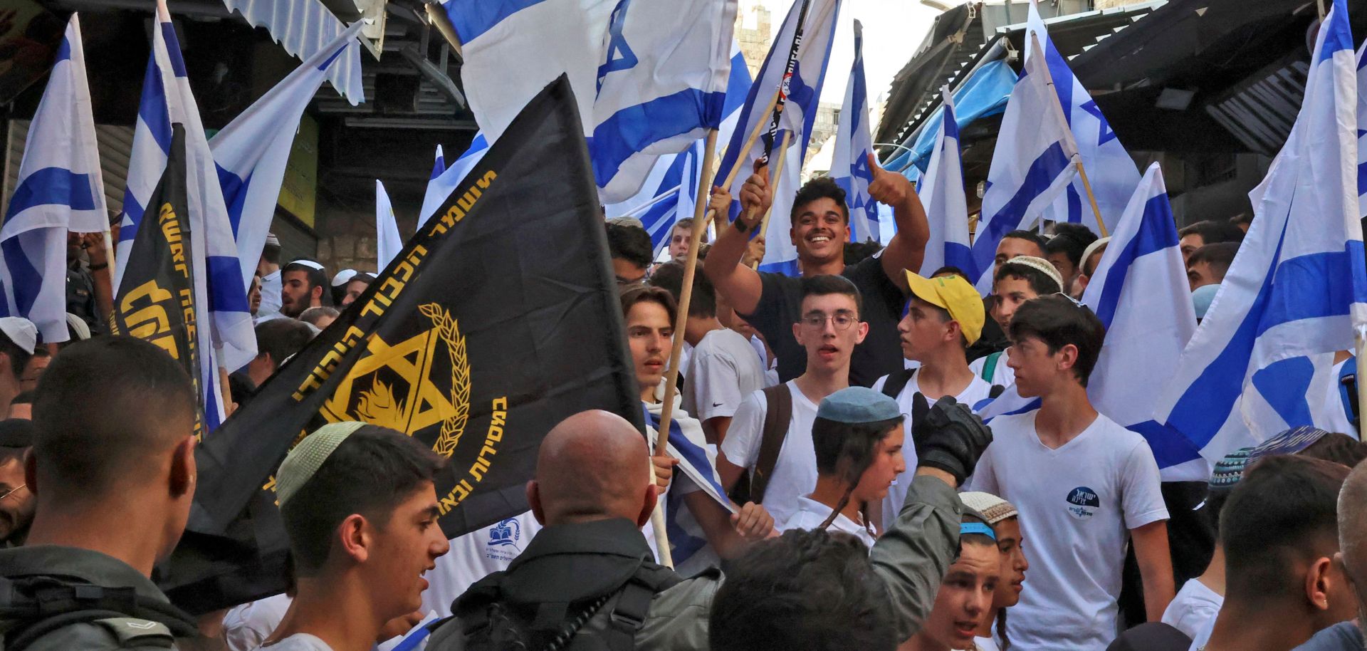 Demonstrators wave the Israeli flag and the banner of the far-right Jewish group "Lehava" (Flame) gather for the "Flag March" on May 29, 2022, marking "Jerusalem Day" in the Old City of Jerusalem.