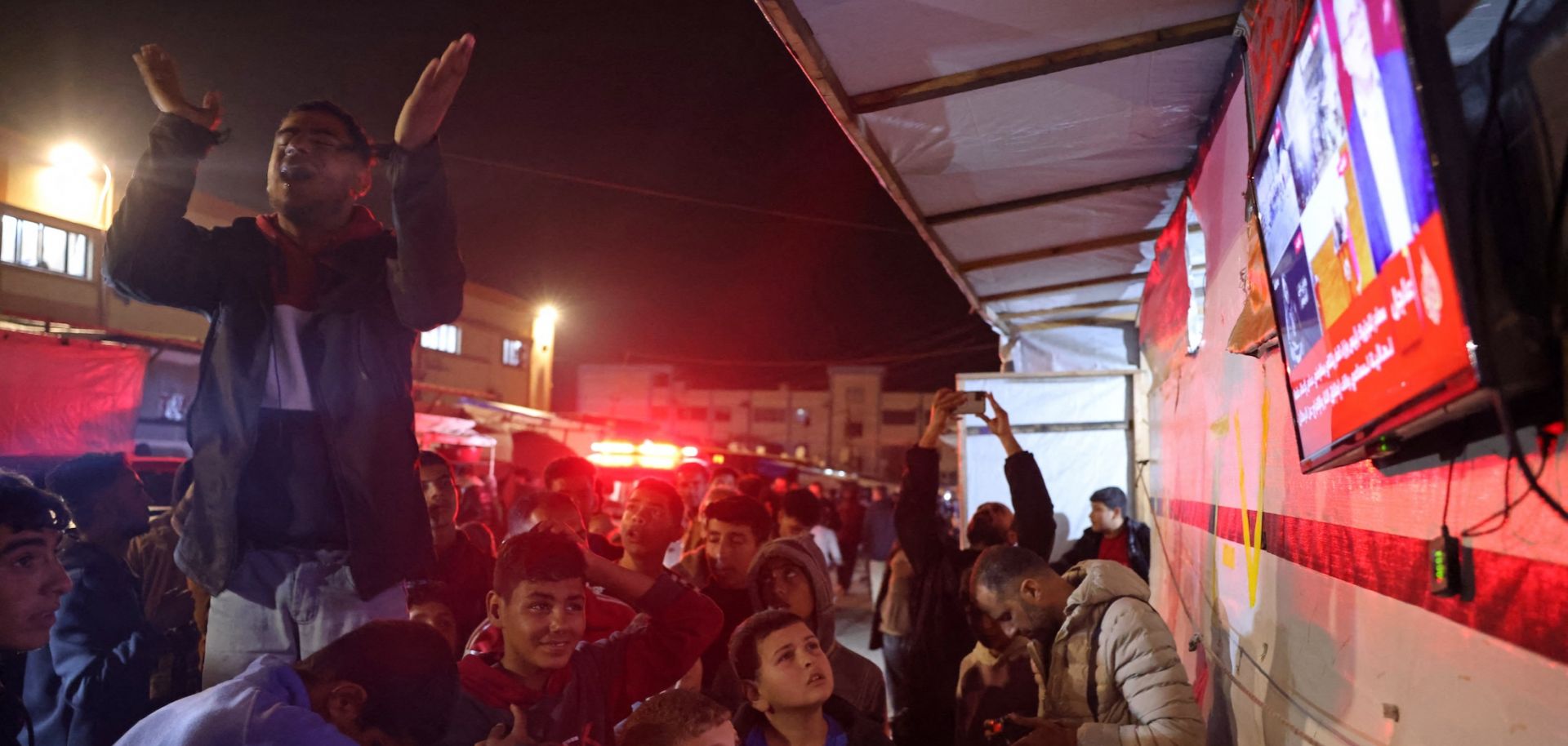 People celebrate while watching news coverage of the Israel-Hamas ceasefire in Khan Yunis in the southern Gaza Strip on Jan. 15, 2025.