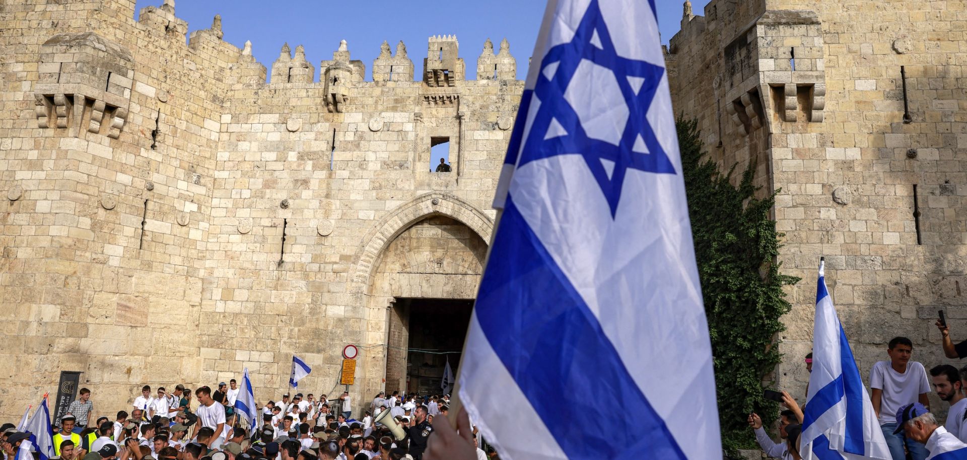 Right-wing activists gather with Israeli flags outside the Damascus Gate of the walled Old City of Jerusalem on May 26, 2025, during a flag march for Jerusalem Day, commemorating the Israeli army's 1967 capture of the city's eastern sector during the Arab-Israeli war.