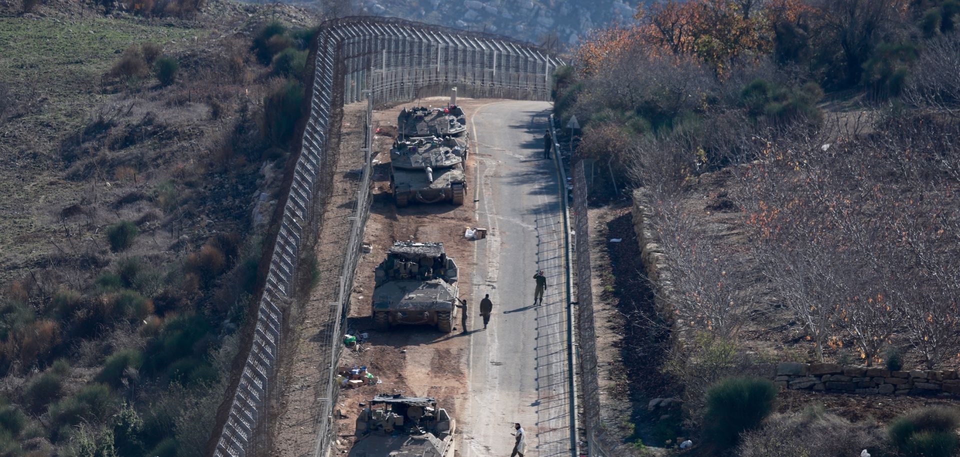 Israeli tanks and armored vehicles line up the area outside the Druze village of Majdal Shams on the fence with the buffer zone that separates the Israeli-annexed Golan Heights from the rest of Syria on Dec. 9, 2024.