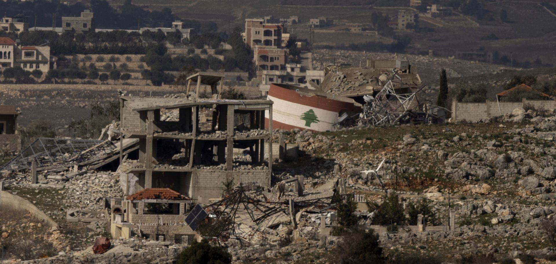 A Lebanese flag painted on a damaged building in a village in southern Lebanon is seen from a position on the Israeli side of the border on Jan. 23, 2025. 