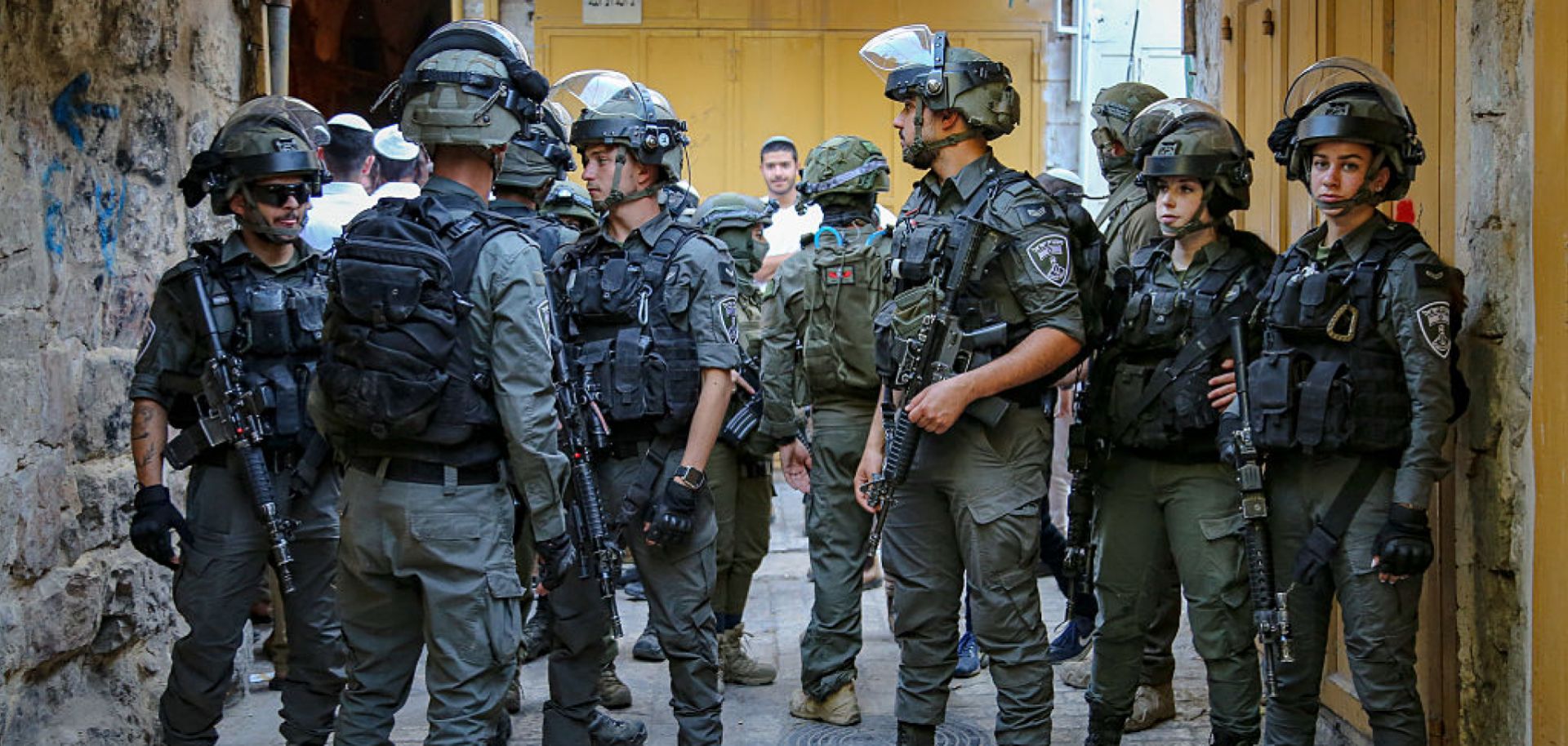 A group of armed Israeli soldiers stands in a narrow alley of the Old City of Hebron, West Bank, on May 31, 2025. 