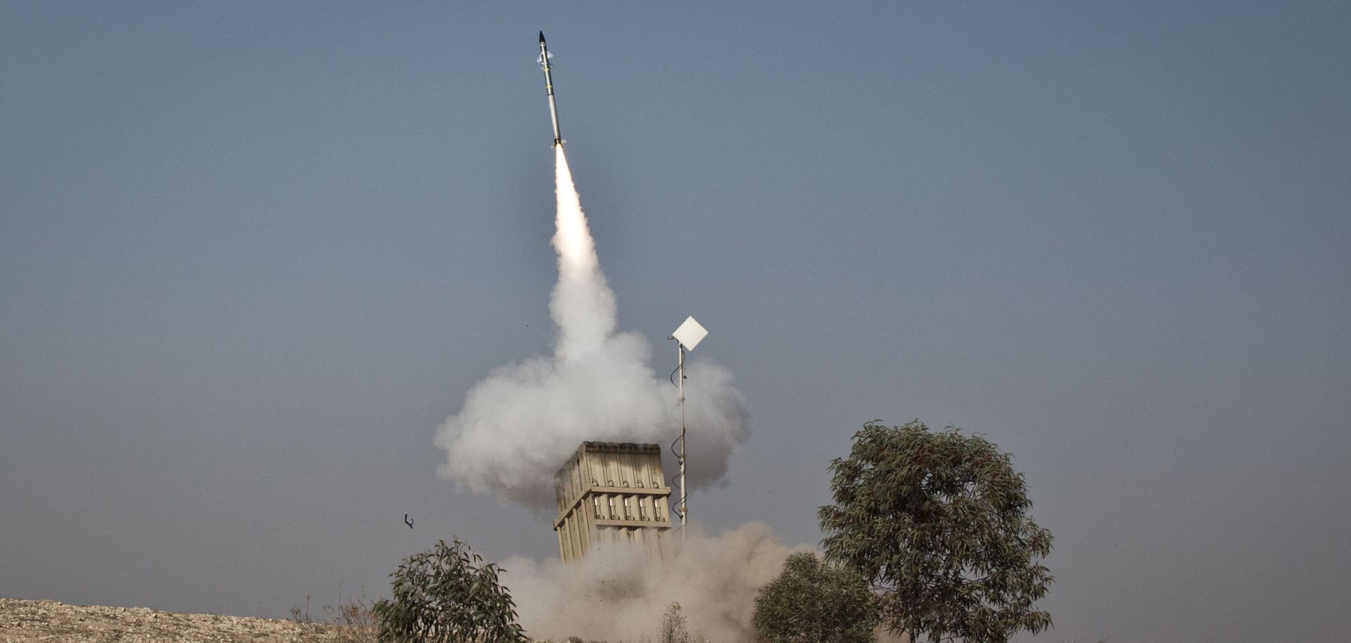 An Israeli soldier lies on the ground as missiles are fired from an Iron Dome anti-missile station on November 15, 2012 near the city of Beer Sheva, Israel. 