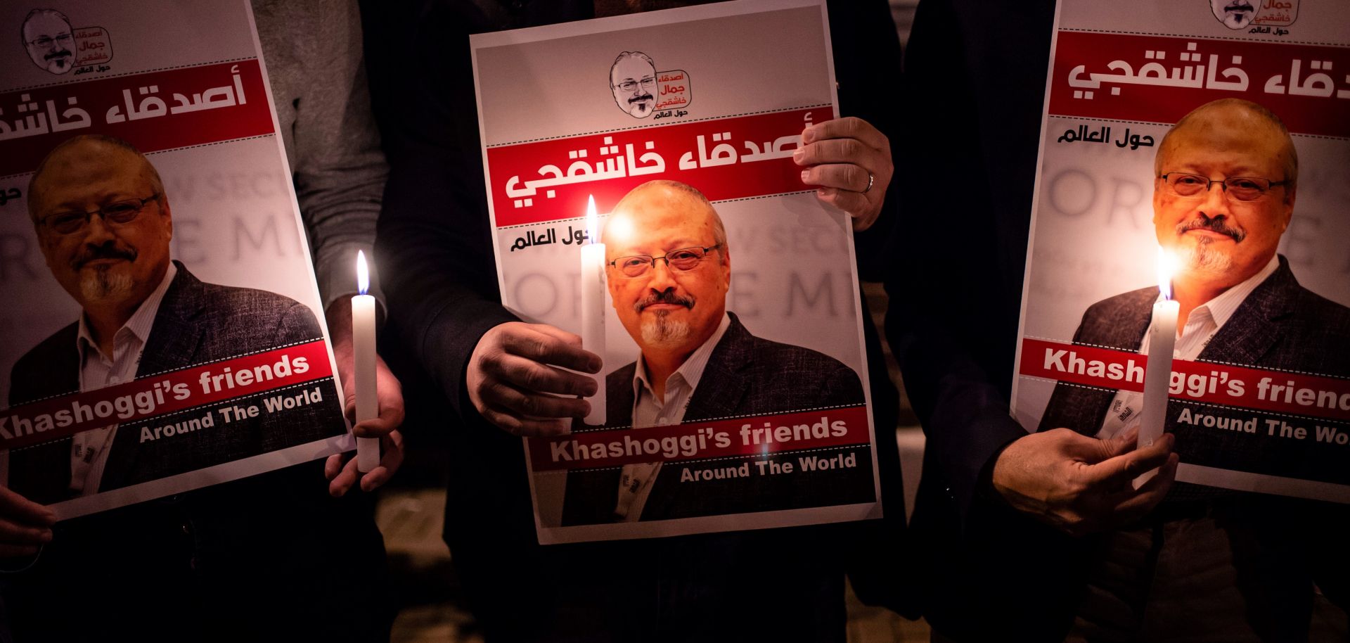 People hold posters depicting murdered Saudi journalist Jamal Khashoggi during a candlelit vigil outside the Saudi consulate in Istanbul on Oct. 25, 2018. 