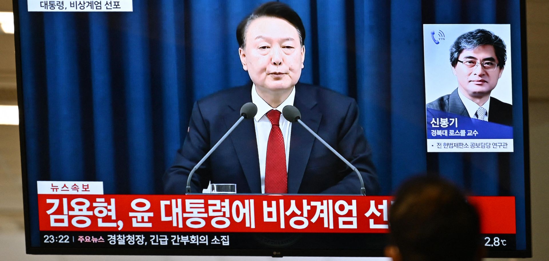 South Korean President Yoon Suk Yeol speaks during a news broadcast on a television at a train station in Seoul on Dec. 3, 2024, after Yoon declared emergency martial law.