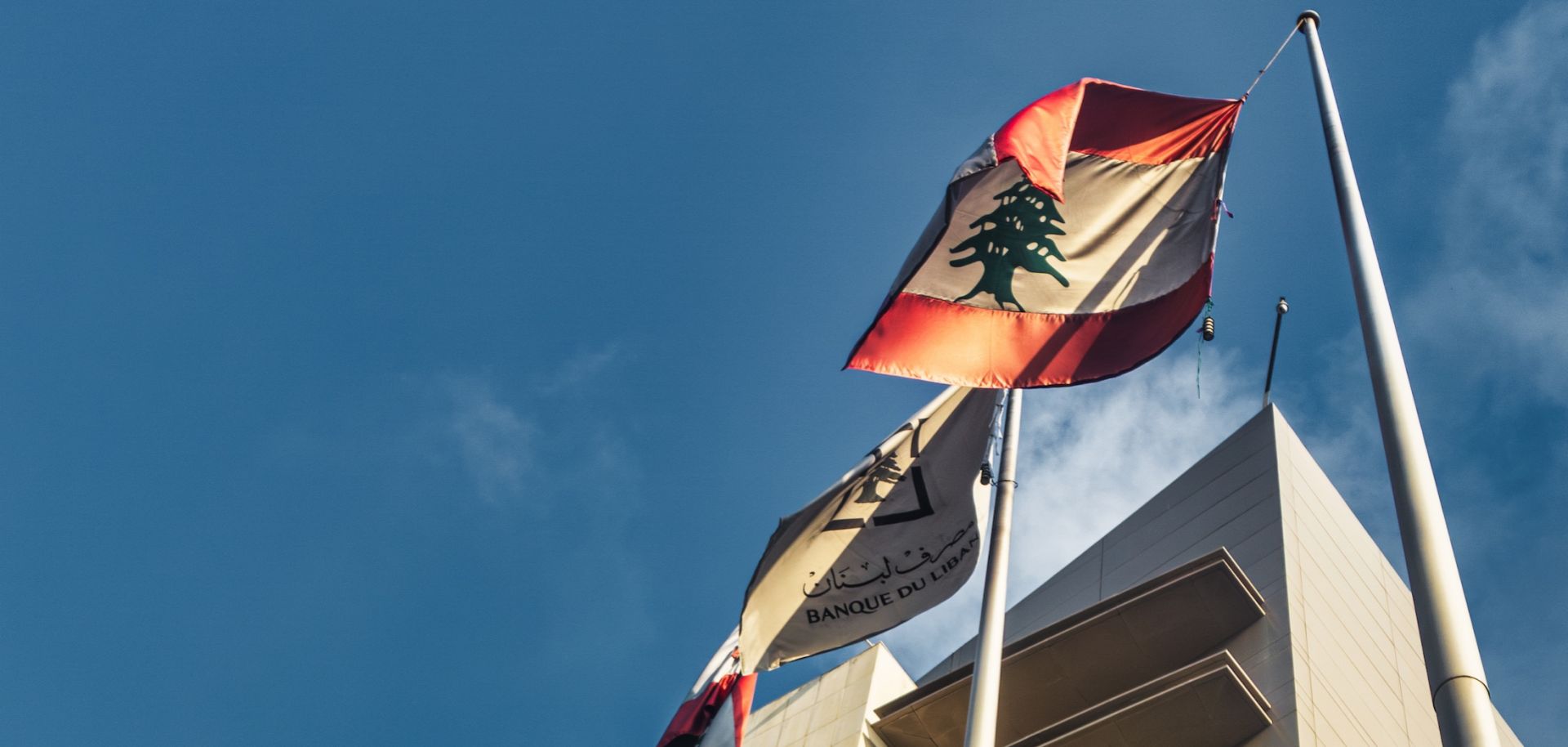 Lebanese flags fly outside of Lebanon's central bank in July 2023.
