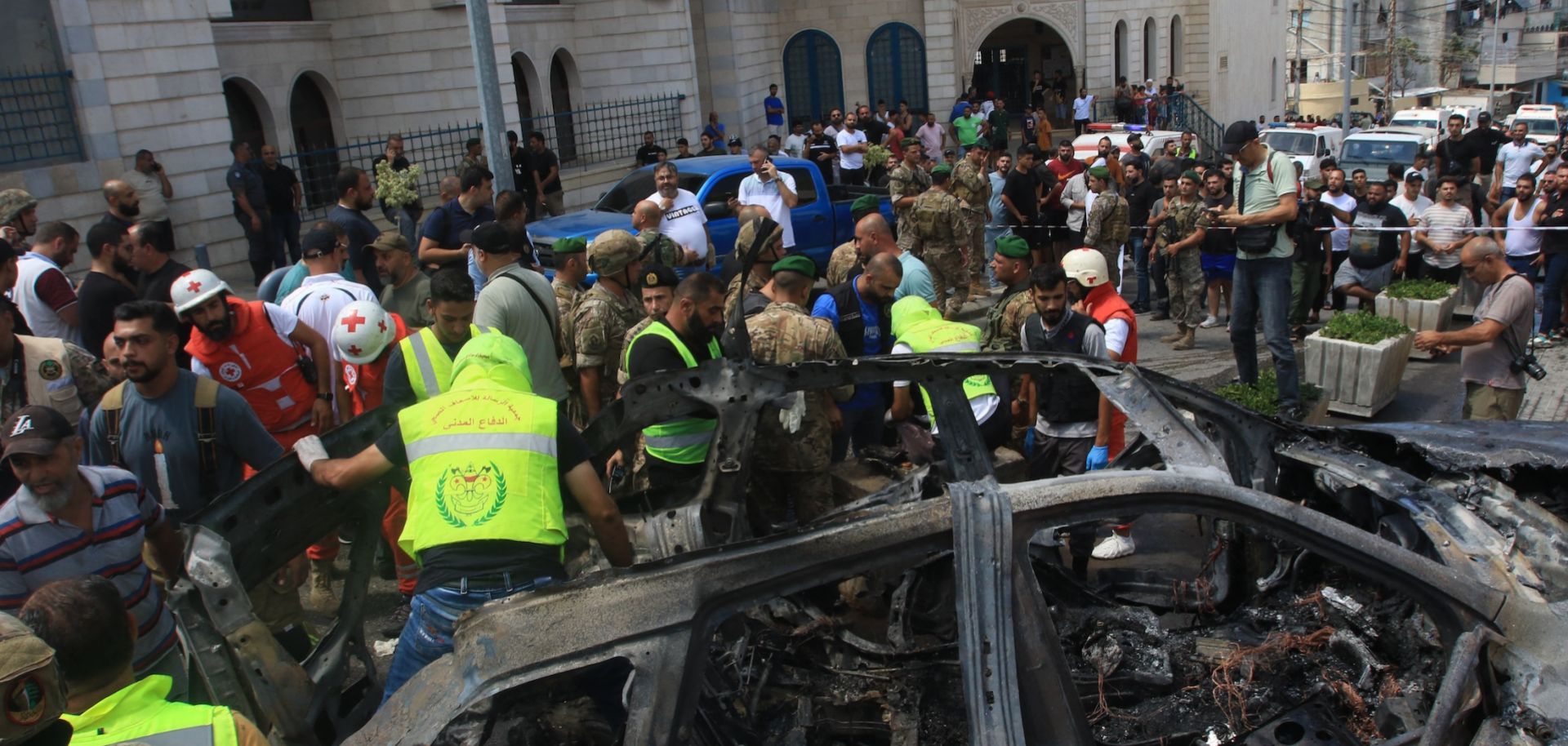 Lebanese authorities inspect a car that was targeted with an Israeli strike and killed a Fatah official in the southern city of Sidon on Aug. 21, 2024. 