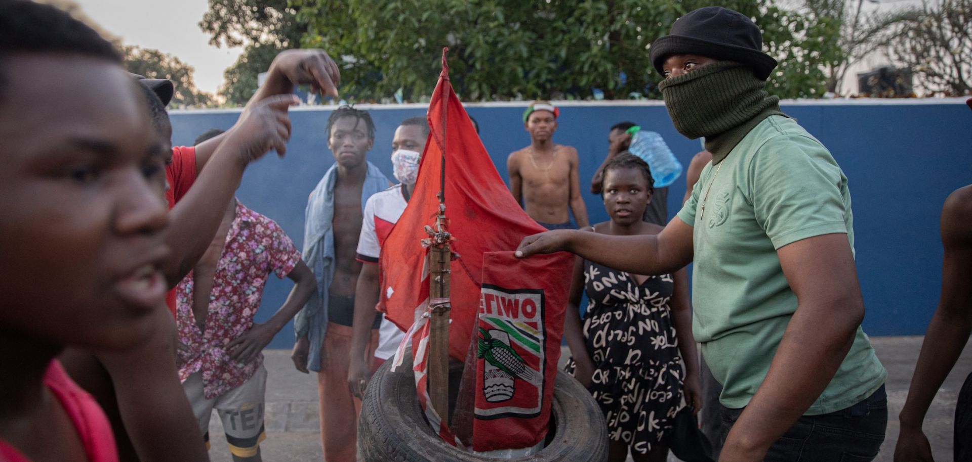 Protesters in Maputo prepare to burn a flag of Mozambique's ruling Frelimo party on Oct. 24, 2024. 