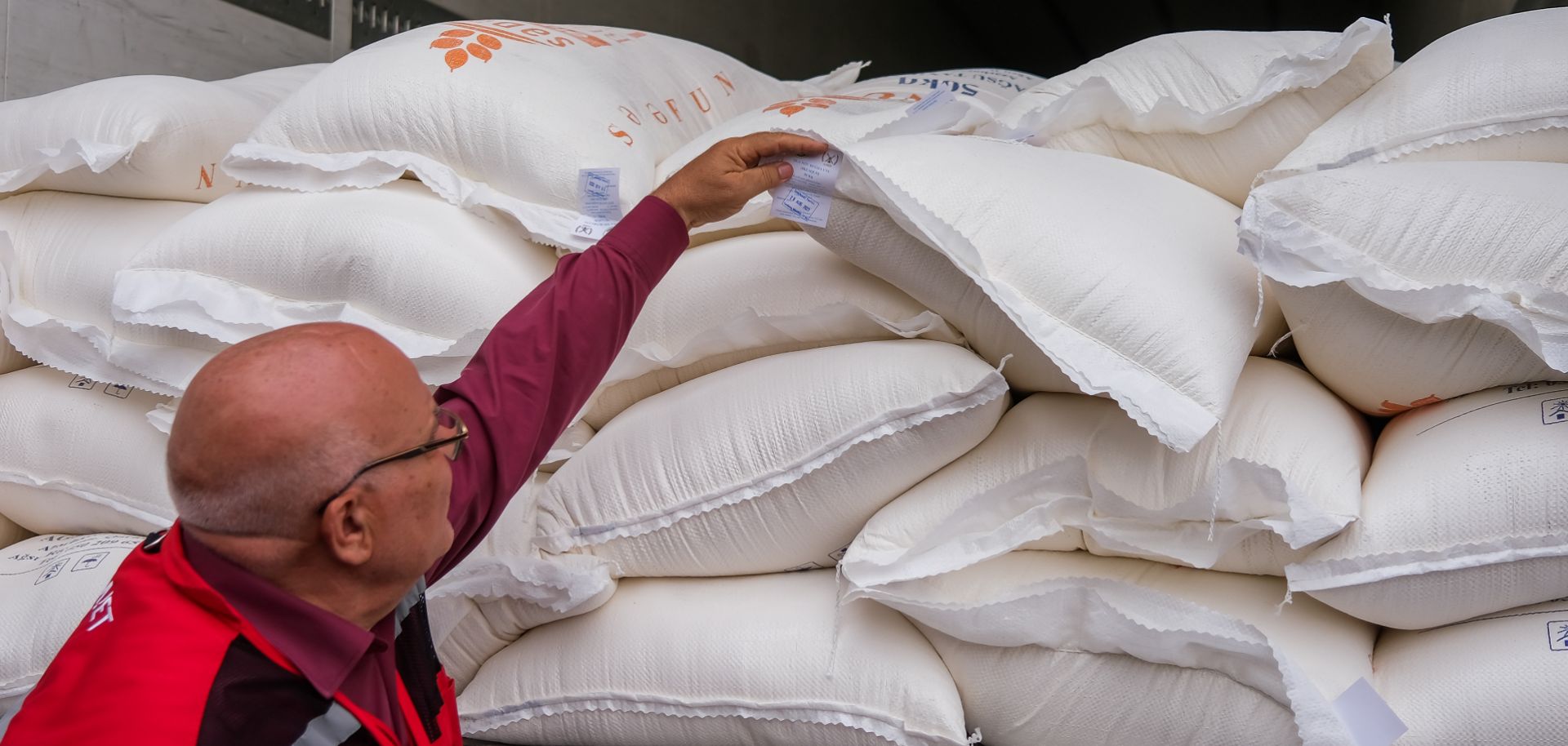 A member of the Red Crescent shows bags of flour on Aug. 30, 2023, in Aghdam, Azerbaijan. 