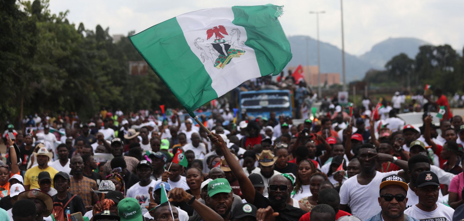 The Nigerian flag is waved above a crowd at a political rally for Labor Party candidate Peter Obi in Abuja, Nigeria, on Sept. 24, 2022. 