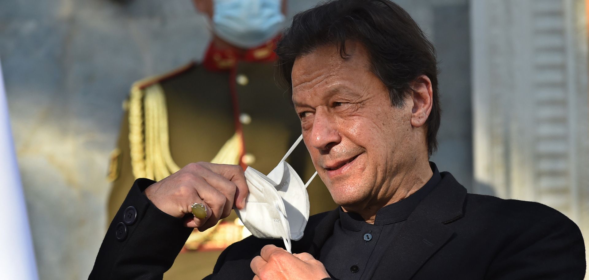 Pakistani Prime Minister Imran Khan removes his facemask during a press conference on Nov. 19, 2020.