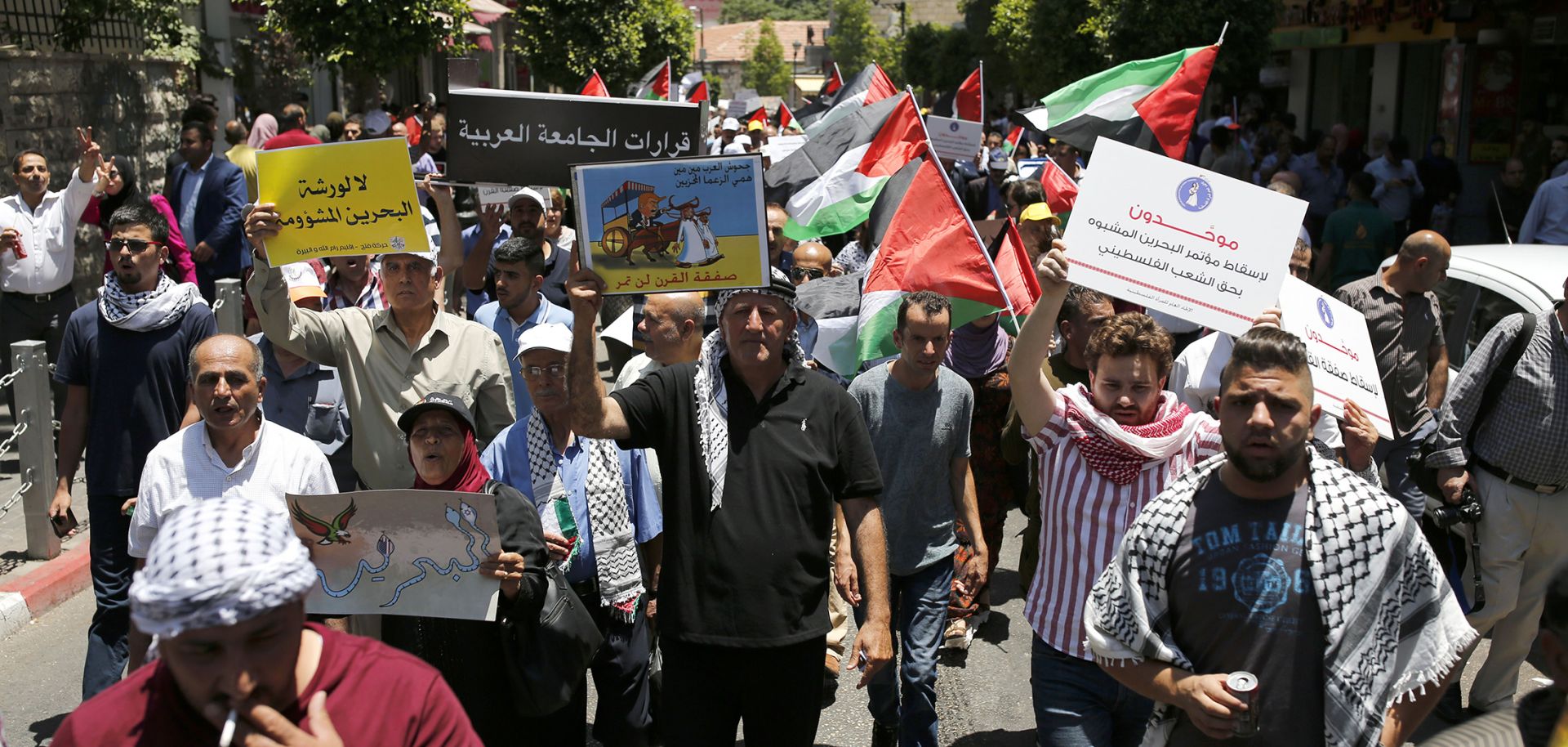 Demonstrators opposed to the U.S.-led plan for Israeli-Palestinian peace march through Ramallah in the West Bank on June 24.
