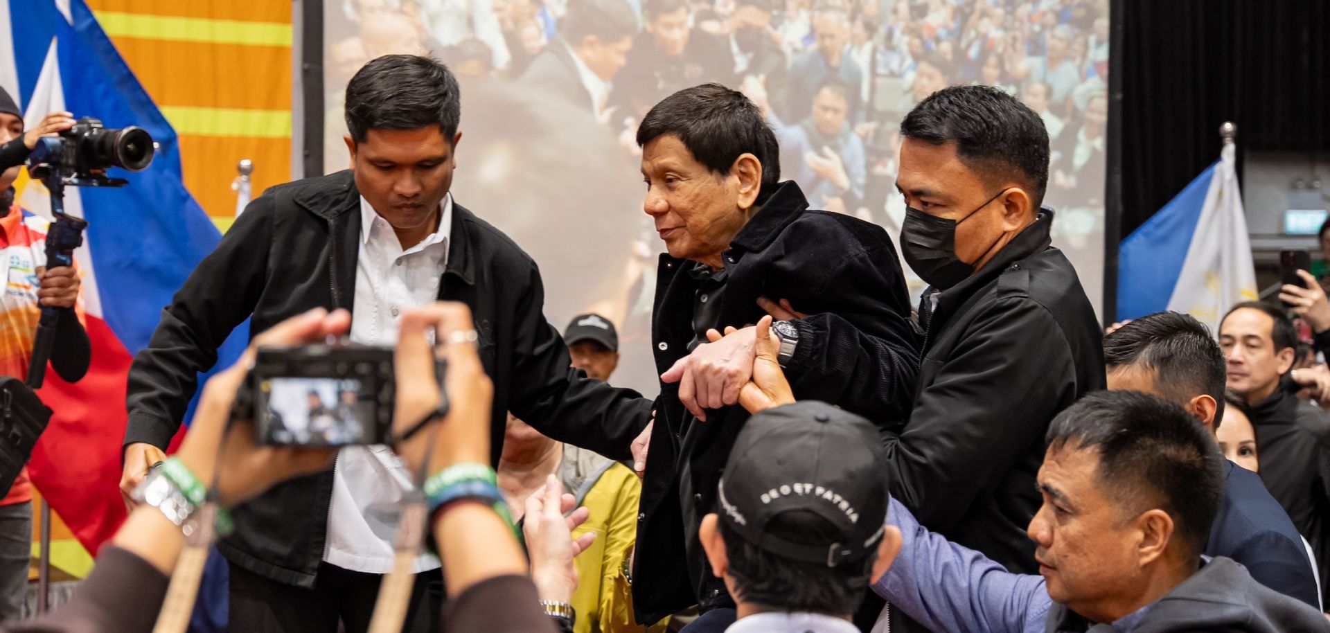 Former Philippine President Rodrigo Duterte is escorted by security personnel as he enters a campaign rally at Southorn Stadium in Hong Kong, China, on March 9, 2025. 