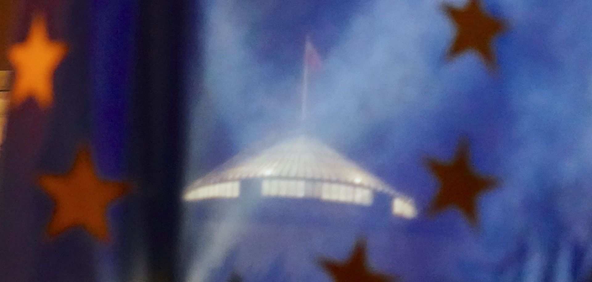 The parliament building is seen through a European flag during a demonstration against a judicial reform pushed by lawmakers of the ruling Law and Justice party on Jan. 23, 2020, in Warsaw, Poland.