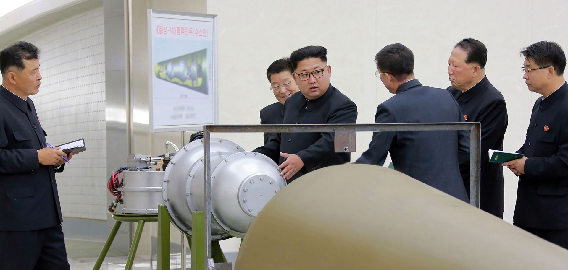 An undated picture released by North Korea's official Korean Central News Agency on Sept. 3 shows North Korean leader Kim Jong-Un (C) looking at a metal casing with two bulges at an undisclosed location. 