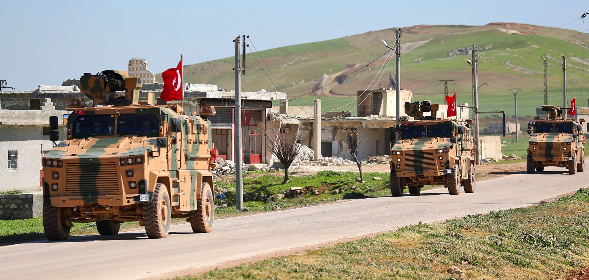 A column of armored Turkish military vehicles proceeds along a road in a demilitarized zone in the western countryside of Syria's Aleppo province on March 8, 2019.