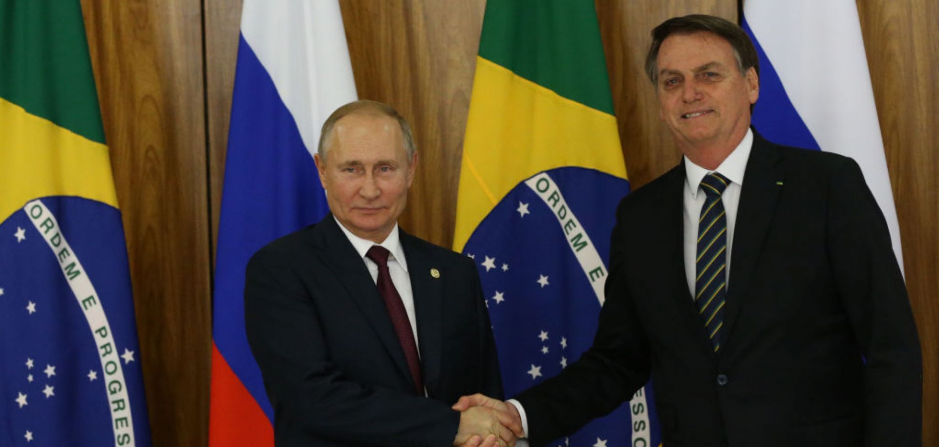 Russian President Vladimir Putin (L) greets Brazilian President Jair Bolsonaro on Nov. 14, 2019, in Brasilia, Brazil, on the sidelines of a BRICS summit.