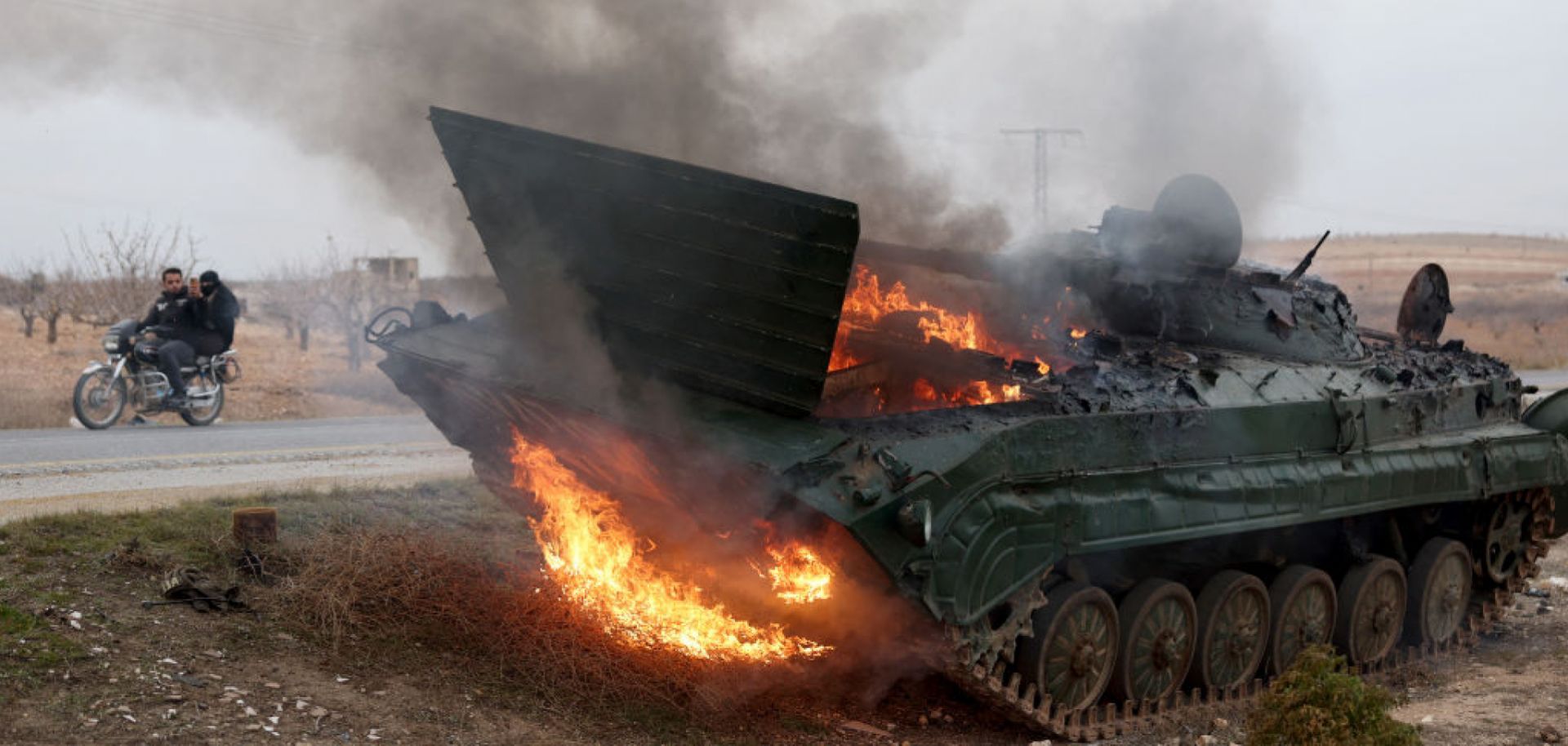 A military vehicle burns after it was hit by Syrian regime forces Dec. 7 in Syria's Hama governorate.