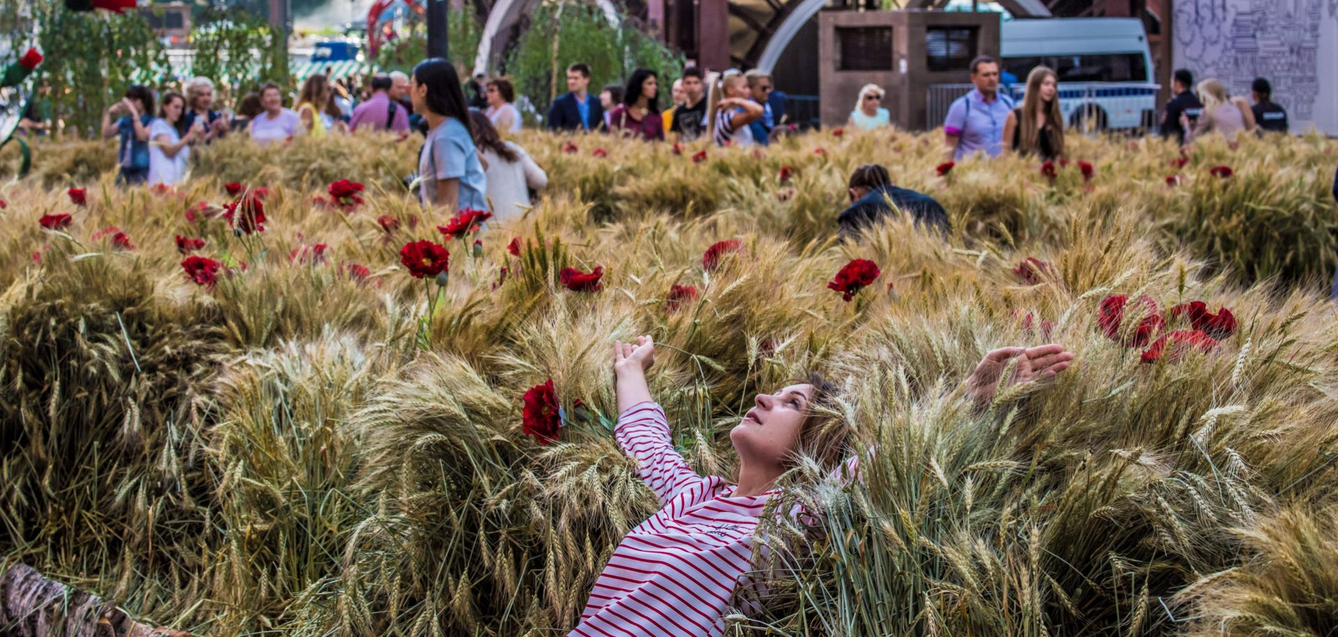 Visitors in downtown Moscow on July 20 explore a wheat field with poppies that was installed during a festival held in Revolution Square next to the State Historical Museum.