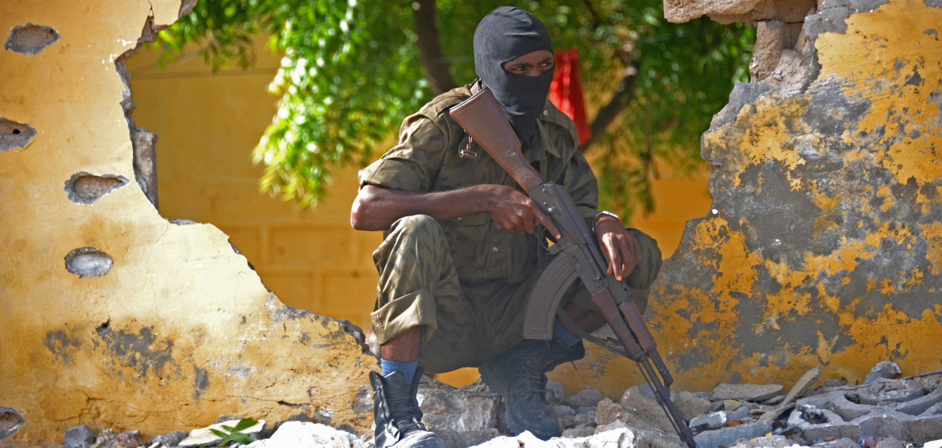 A Somali soldier stands guard next to the site where Al Shebab militants carried out a suicide attack against a military intelligence base in Mogadishu on June 21, 2015.