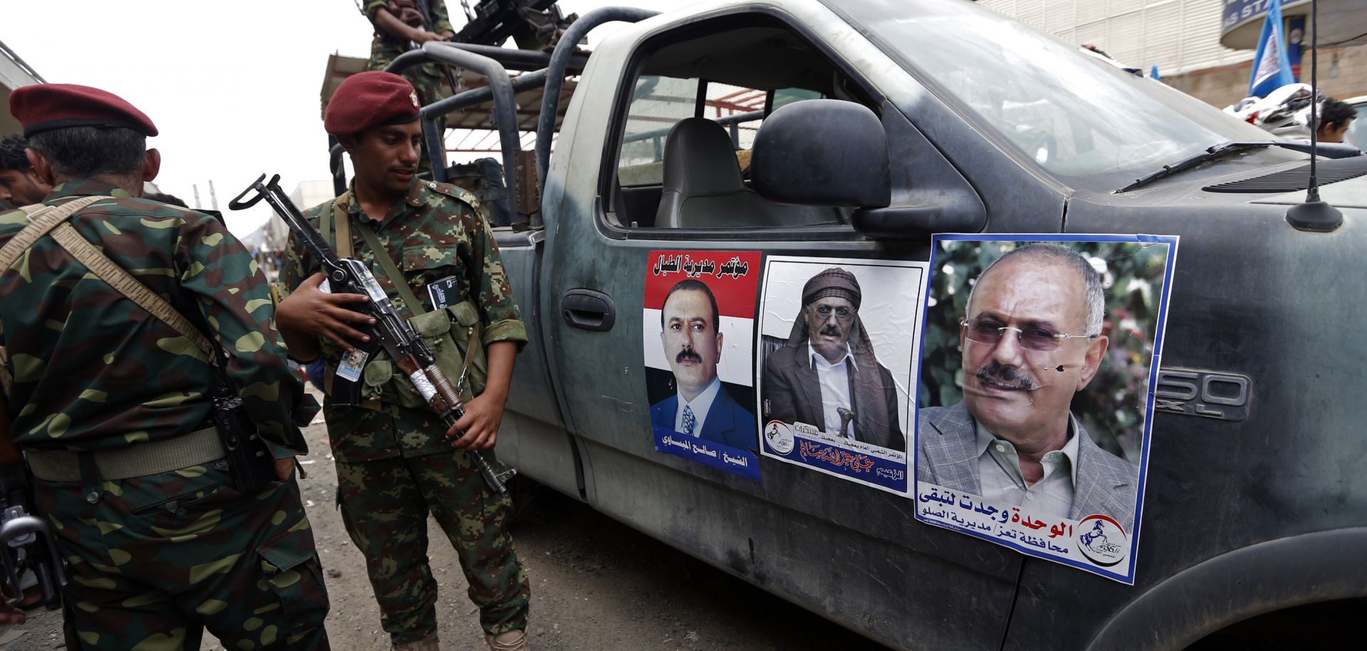Forces loyal to Yemen's former President Ali Abdullah Saleh (shown on poster) stand guard on Aug. 24 in Sabaeen Square in the capital, Sanaa. 
