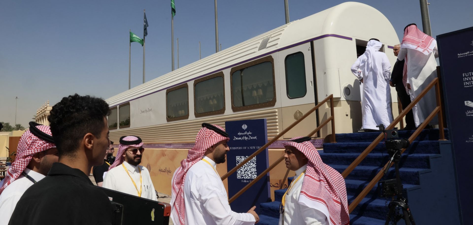 Guests stand outside a model carriage of the "Dream of the Desert" ultra-luxury train on display during the Future Investment Initiative conference in Riyadh, Saudi Arabia, on Oct. 28, 2025.