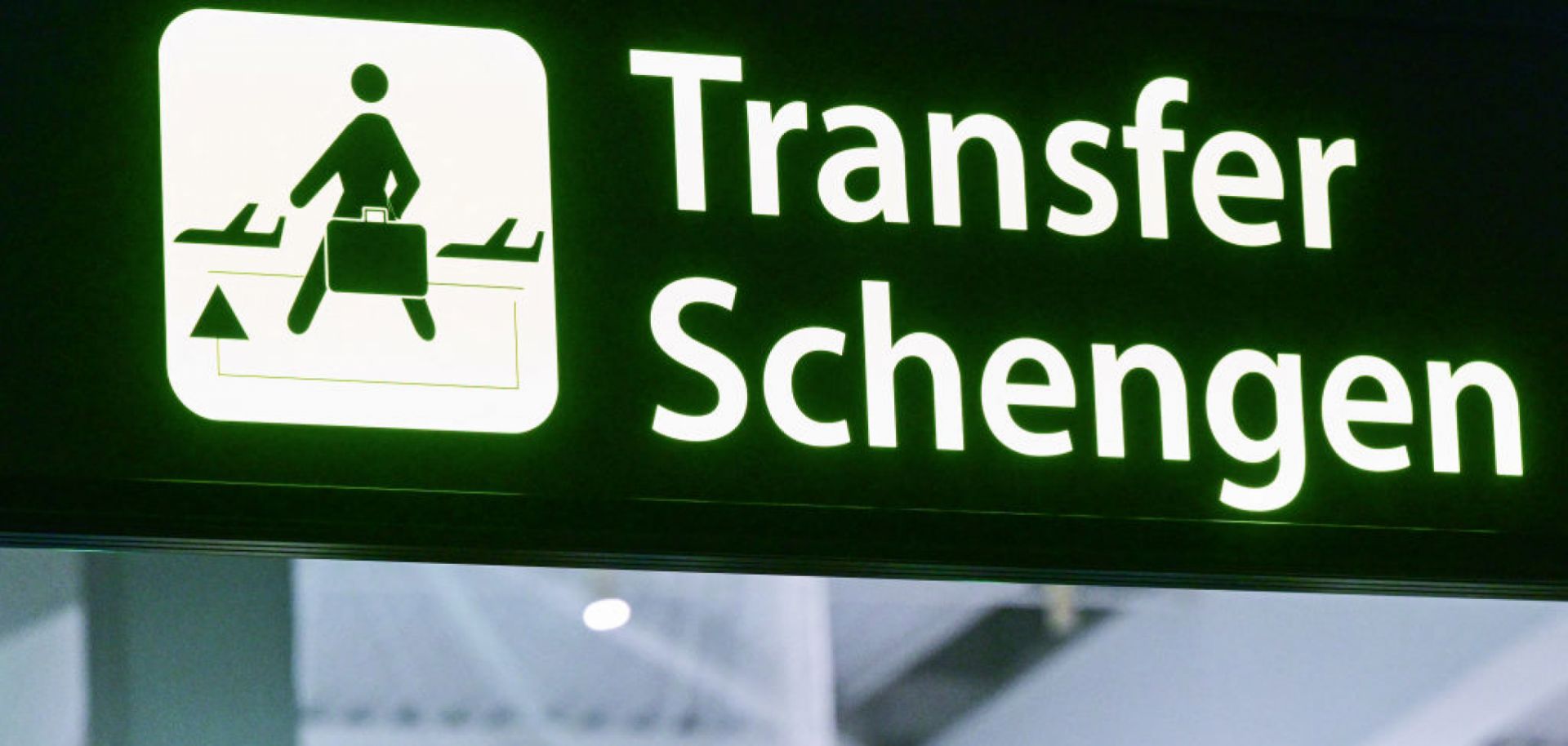 A newly installed sign pointing to Schengen transfer flights is pictured next to EU and Romanian flags on March 31, 2024. 