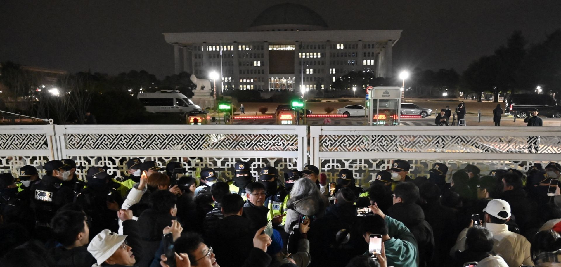 People gather in front of the main gate of the National Assembly in Seoul, South Korea on Dec. 4, 2024, after President Yoon Suk Yeol declared emergency martial law. 