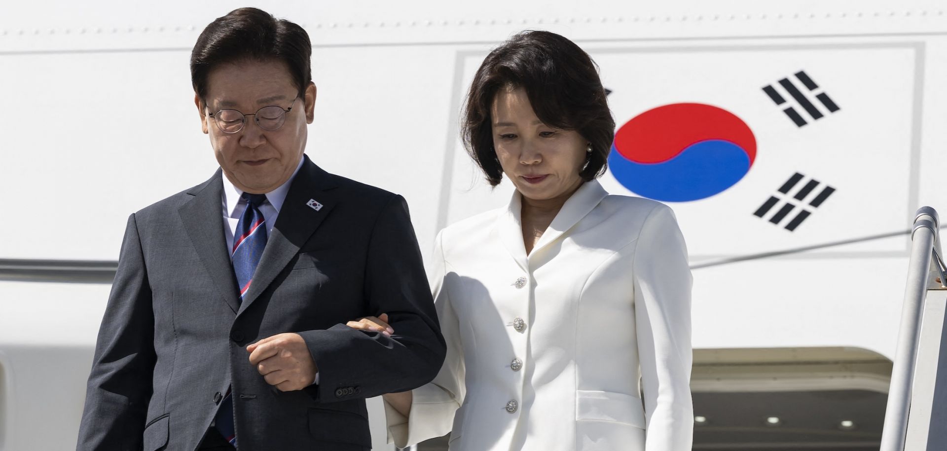 South Korean President Lee Jae Myung (left) and his wife disembark from the plane at Geneva Airport as they arrive to attend the G7 summit on June 16, 2026.