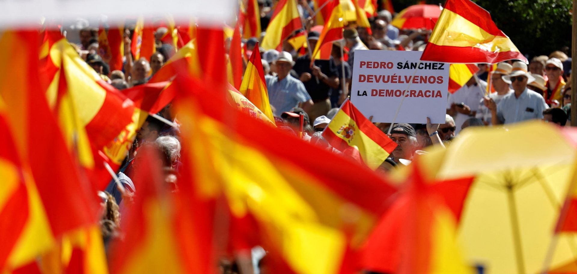 A protester holds a sign reading "Pedro Sanchez, give us back the democracy" during a demonstration in Madrid against Spanish Prime Minister Pedro Sanchez's government on June 8, 2025.