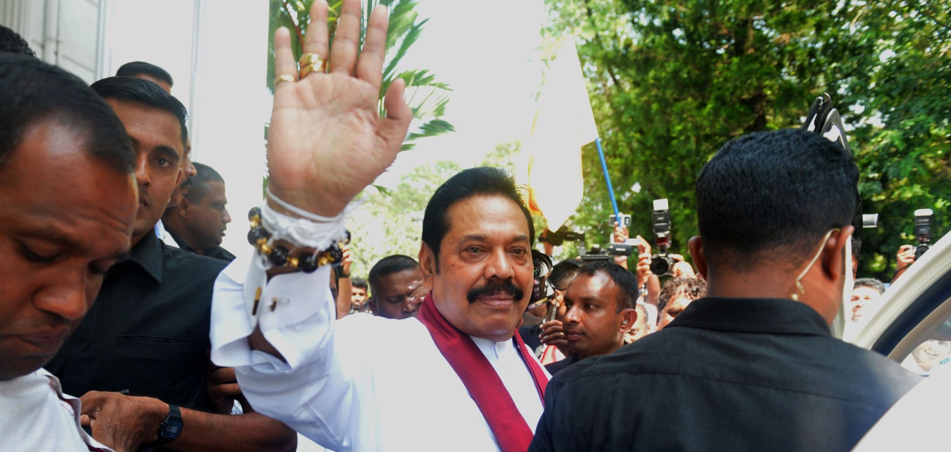 Sri Lanka's newly appointed prime minister, Mahinda Rajapaksa, waves to supporters after a ceremony to assume duties in Colombo on Oct. 