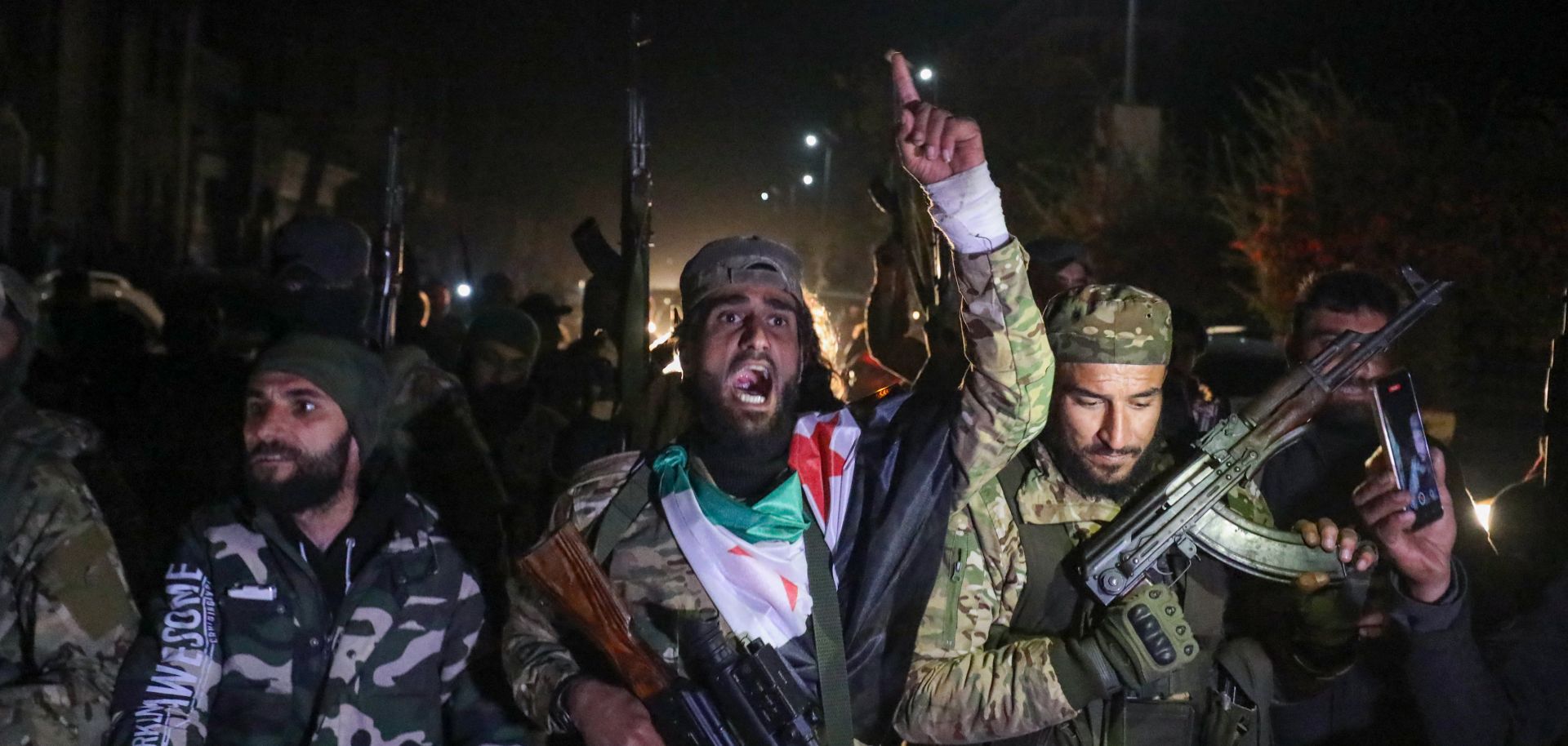 Rebel fighters celebrate in the streets of Homs, Syria, in the early hours of Dec. 8, 2024, after seizing control of the city.