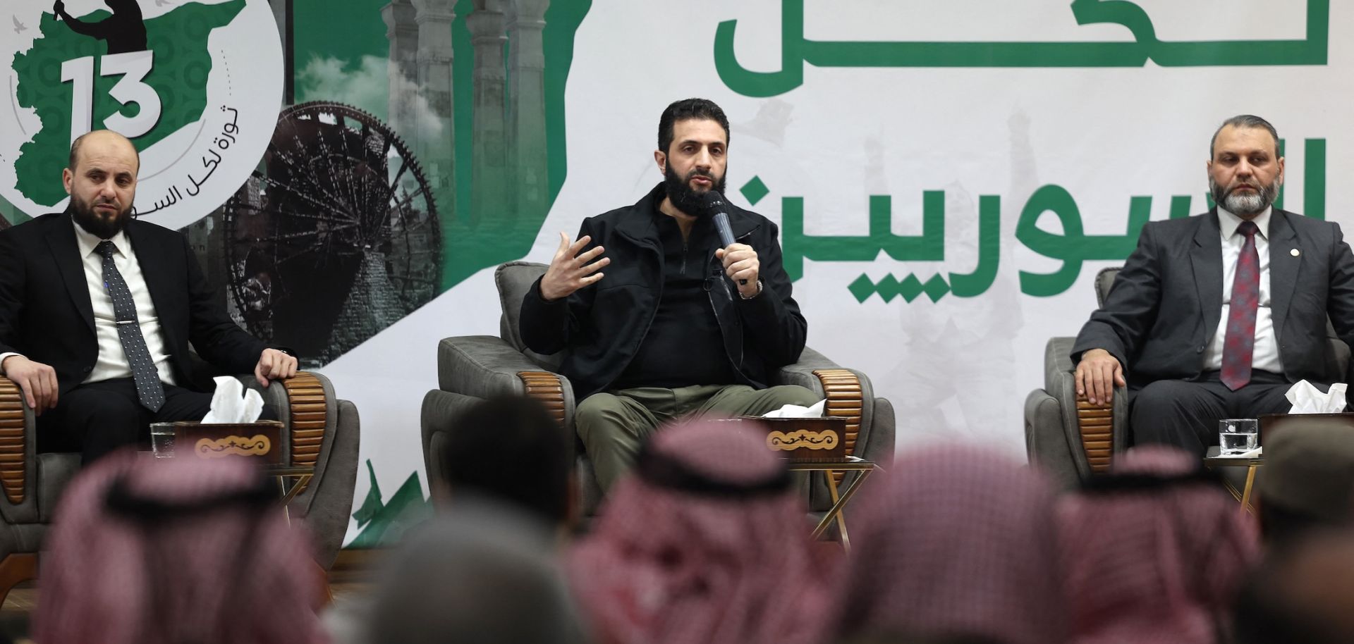 Abu Mohammed al-Golani (C), the head of Syria's leading insurgent group Hayat Tahrir al-Sham, speaks during a press conference near Syria's northern Bab al Hawa border crossing with Turkey late on March 12, 2024.