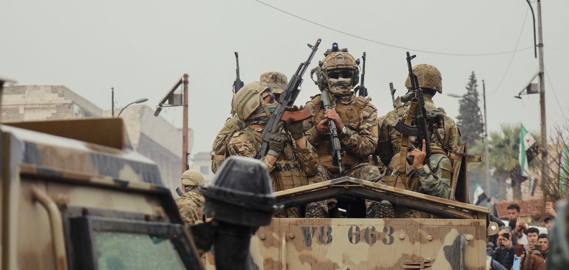Soldiers ride atop an armored vehicle during a military parade in Idlib, Syria, on Dec. 8, 2025. 