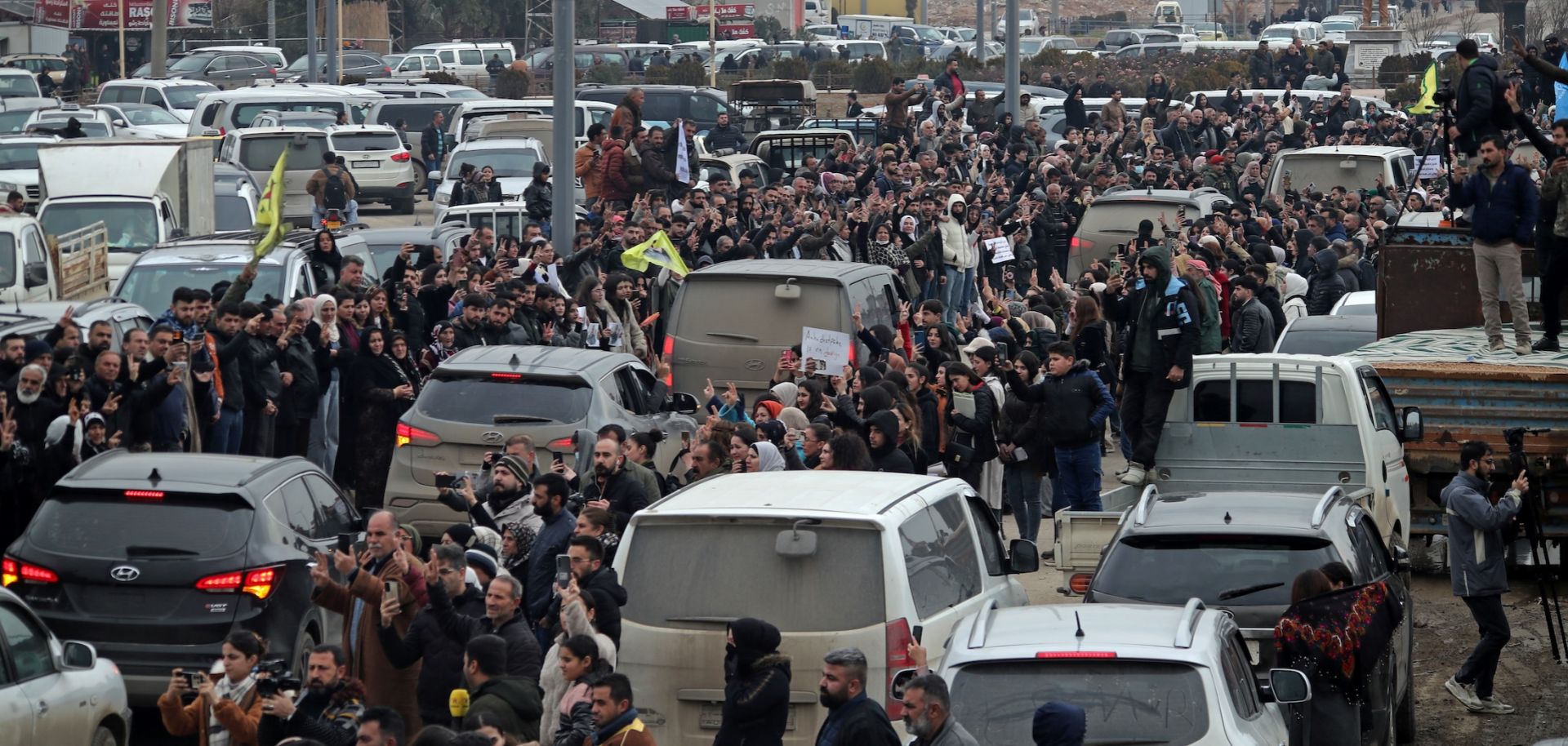 Citizens gather to welcome the arrival of vehicles transporting Kurdish fighters from the northern city of Aleppo to the Kurdish-controlled northeastern city of Qamishli on Jan. 11, 2026.