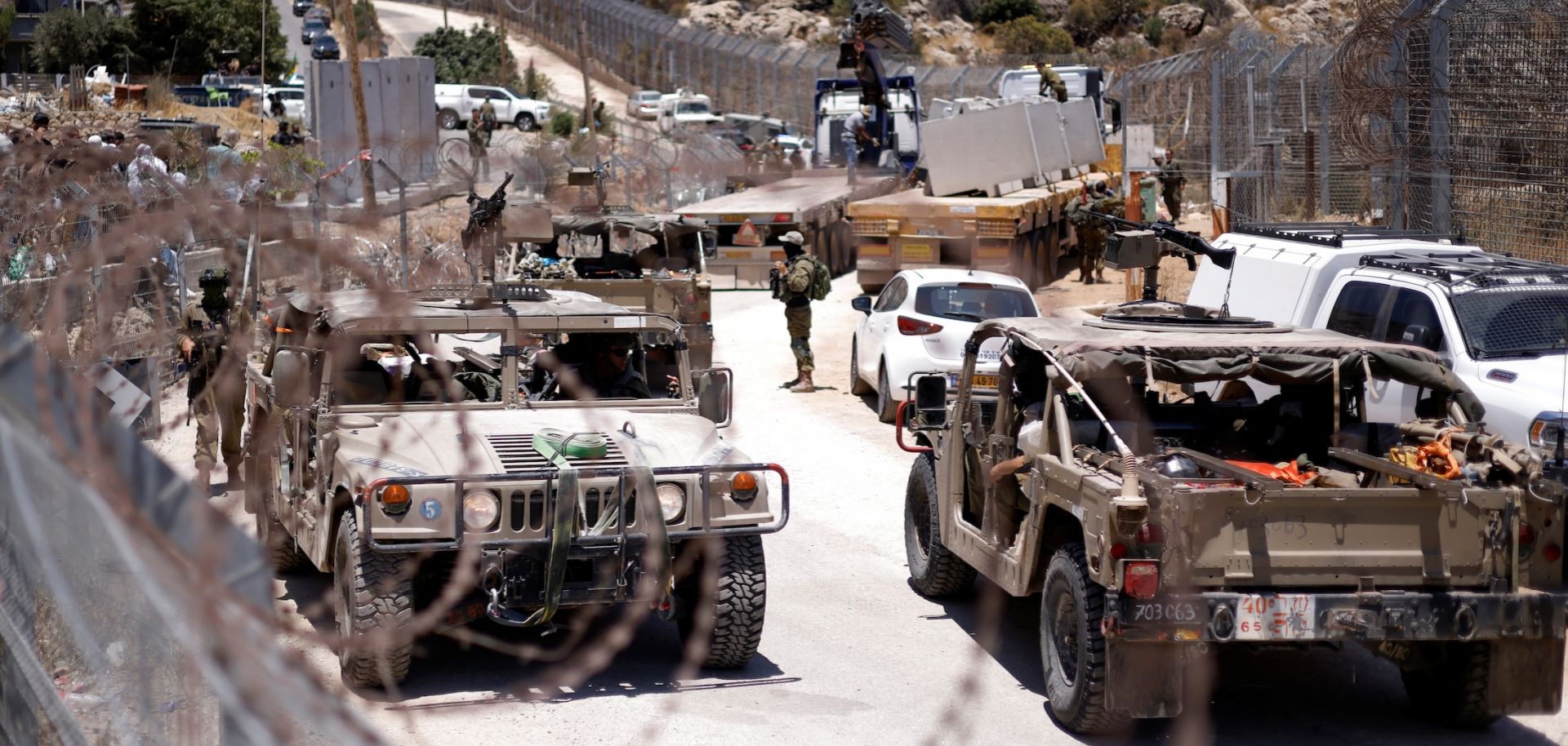 Israeli military vehicles drive along a border fence, near the town of Majdal Shams, in the Israeli-annexed Golan Heights, on July 17, 2025. 