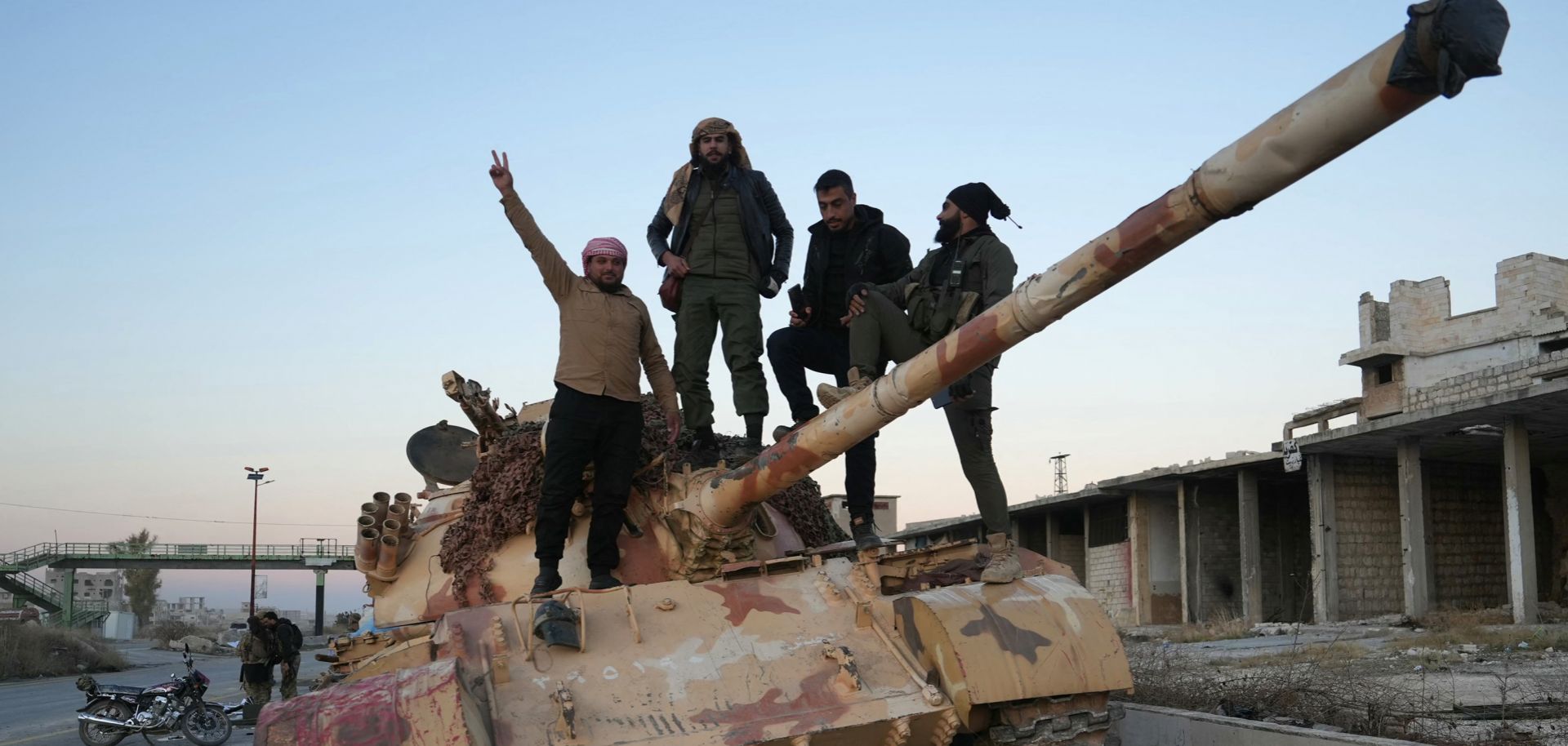 Rebel fighters pose for a picture on a tank on a road leading to Syria's northwestern Idlib province on Nov. 30, 2024. 