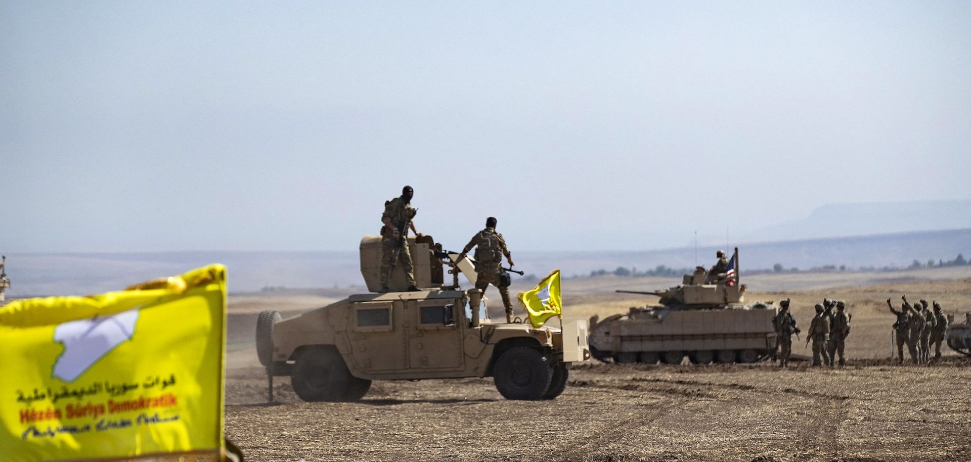 Fighters of the Syrian Democratic Forces (SDF) stand atop a humvee in Syria's northeastern Hasakah province during a joint military exercise with the U.S.-led coalition against the Islamic State on Sept. 7, 2022.