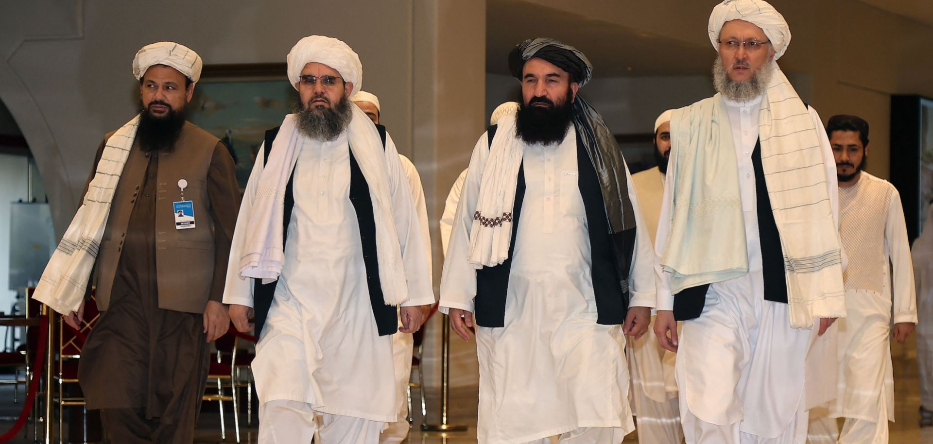 A delegation of Afghan Taliban officials walks down a hotel lobby in Doha, Qatar, in August 2021. 