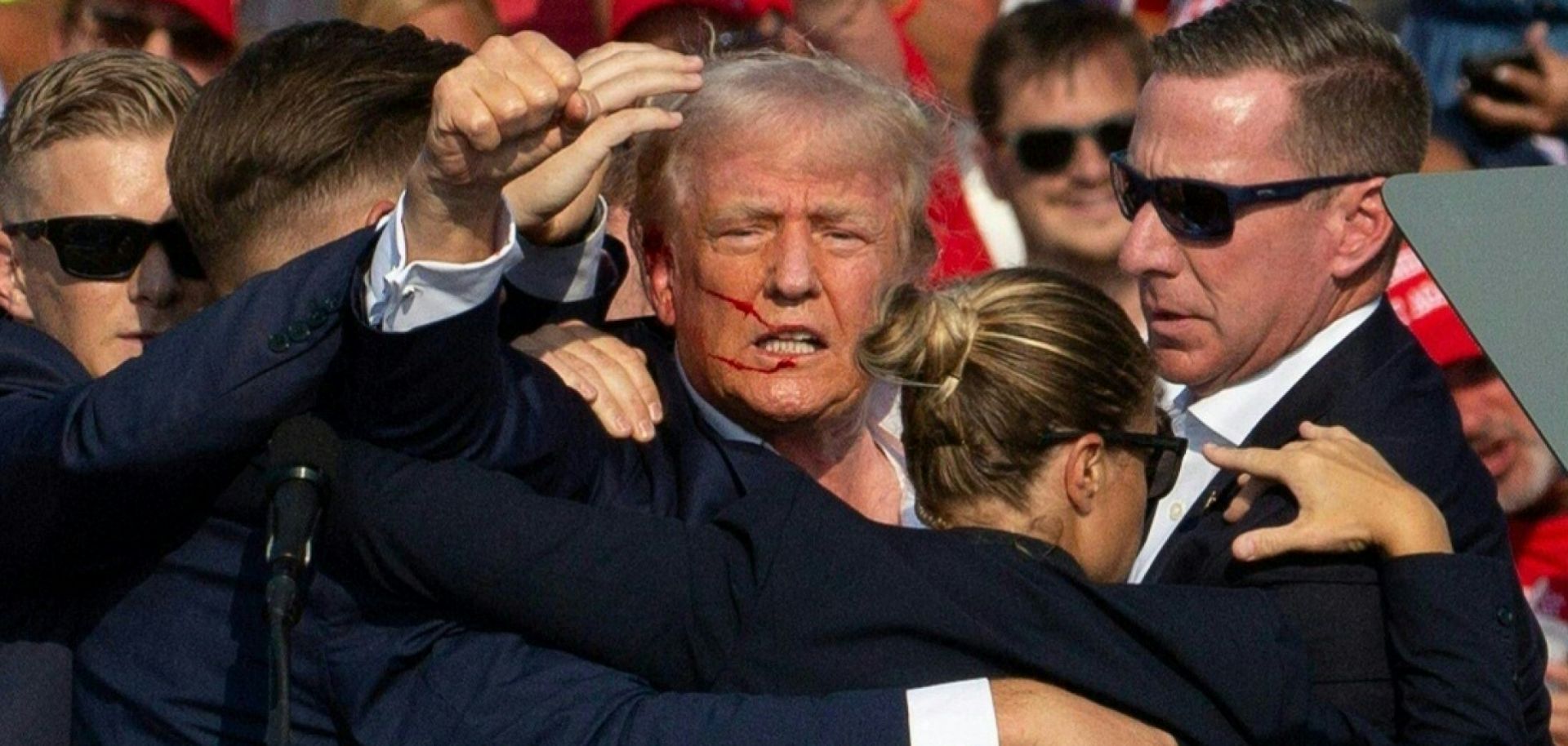 Republican presidential candidate Donald Trump with blood on his face surrounded by secret service agents as he is taken off the stage at a July 13 campaign event in Butler, Pennsylvania.